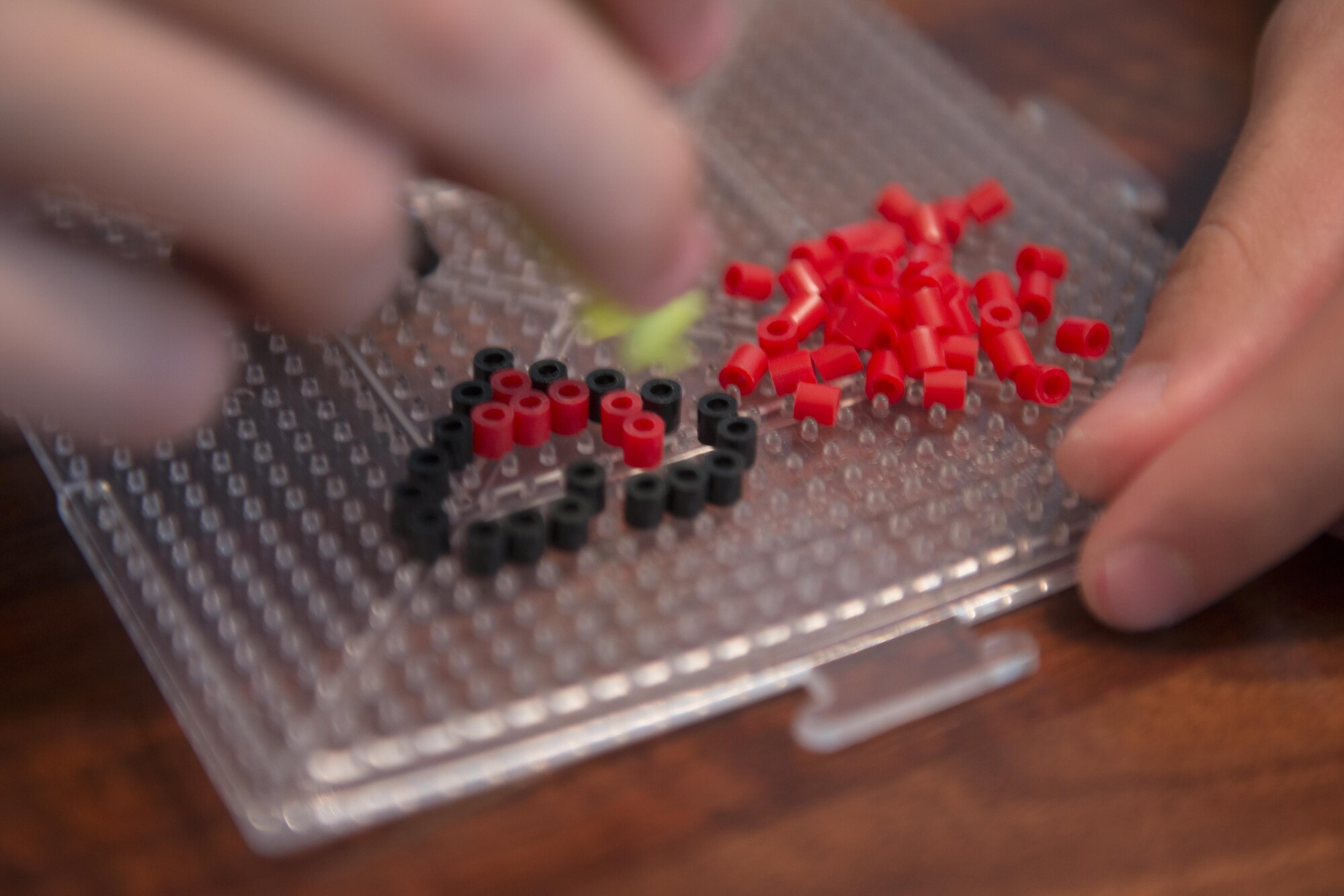 Robert Waid creates a heart out of plastic fusible beads July 25, 2016, at his home in North Pole, Alaska. Depending on how difficult or big a project is, some of Waid’s pieces of art can take several hours to make. (U.S. Air Force photo by Staff Sgt. Ashley Nicole Taylor)