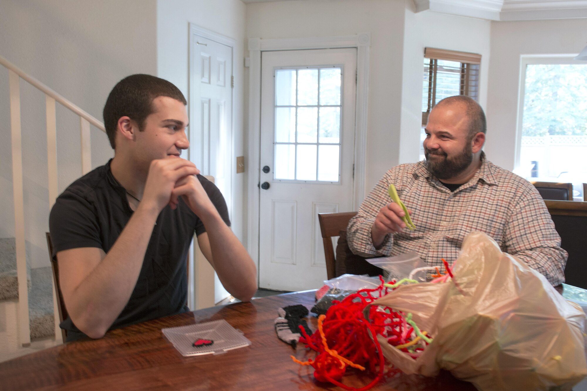 Department of the Air Force Jack Waid, the 354th Fighter Wing historian, jokes with his son Robert, after Robert completed one of his pieces of art at their home July 25, 2016, in North Pole, Alaska. The Waid family plays an important role in Robert’s life and supports him in selling his art throughout the local area. (U.S. Air Force photo by Staff Sgt. Ashley Nicole Taylor)