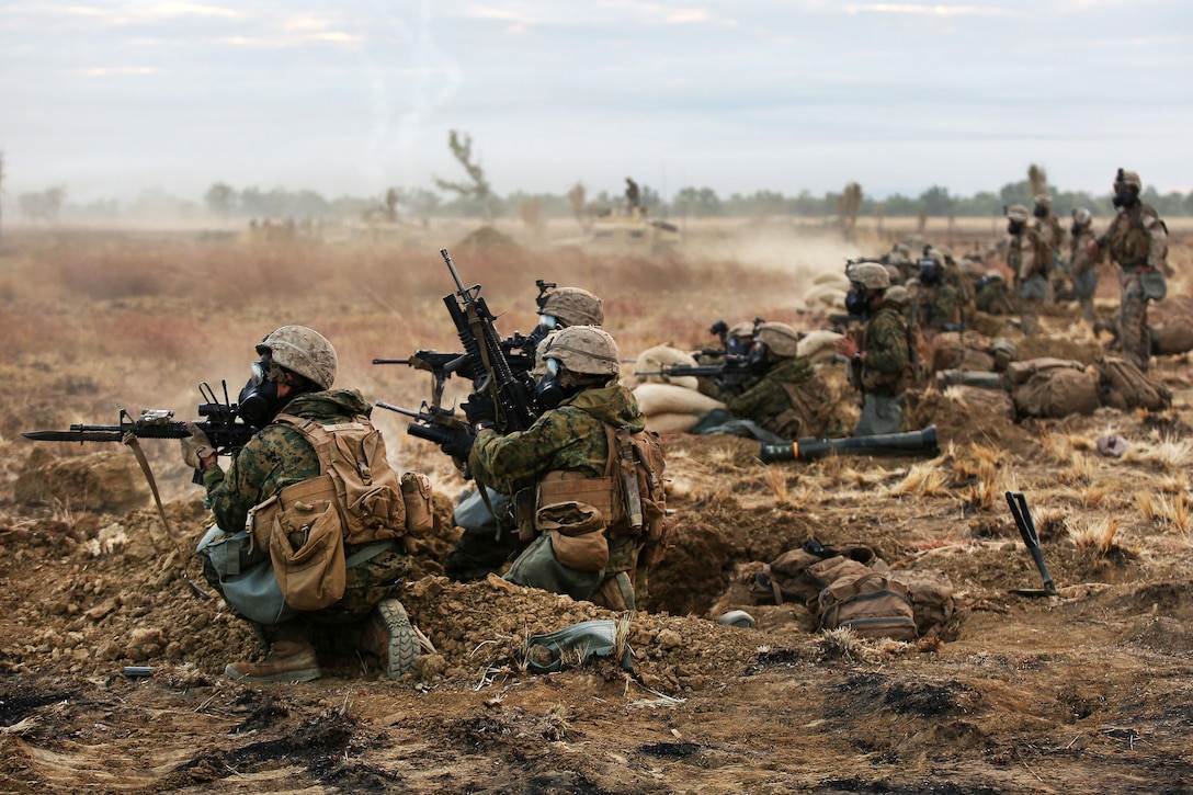 Marines fire weapons at targets during a simulated attack with CS gas, also known as tear gas, during live-fire training as part of Exercise Koolendong 16 at Bradshaw Field Training Area, Northern Territory, Australia, Aug. 18, 2016. Marine Corps photo by Sgt. Sarah Anderson