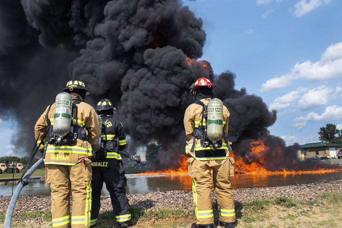 Air Force Reserve firefighters watch a fuel fire build before extinguishing it during Exercise Patriot Warrior 2016 at the airport at Fort McCoy, Wis., Aug. 18, 2016. Air Force photo by Tech. Sgt. Nathan Rivard