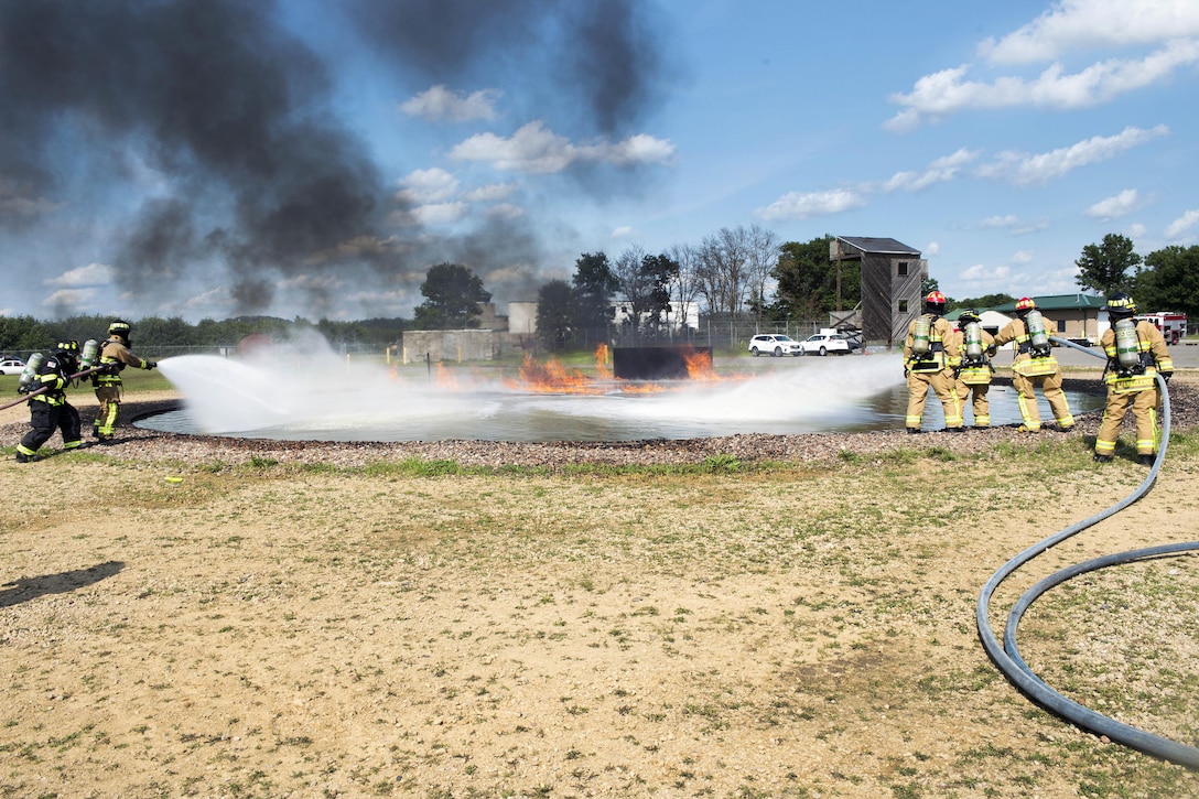 Two Air Force Reserve firefighting teams extinguish a fuel fire during Exercise Patriot Warrior 2016 at the airport at Fort McCoy, Wis., Aug. 18, 2016. Air Force photo by Tech. Sgt. Nathan Rivard