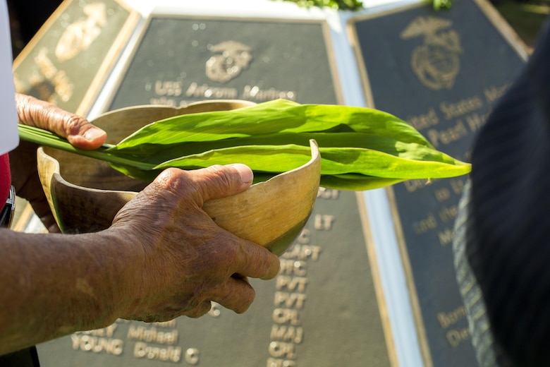Minister Kahu Kelekona Bishaw performs a traditional Hawaiian blessing during the Marine Memorial Rededication Ceremony at the USS ARIZONA Education Center, Honolulu, Hawaii, Aug. 19, 2016.  The significance of the blessing is that fresh Hawaiian water is always used to represent rebirth and the maile lei, the plant, for continued growth and prosperity. 
