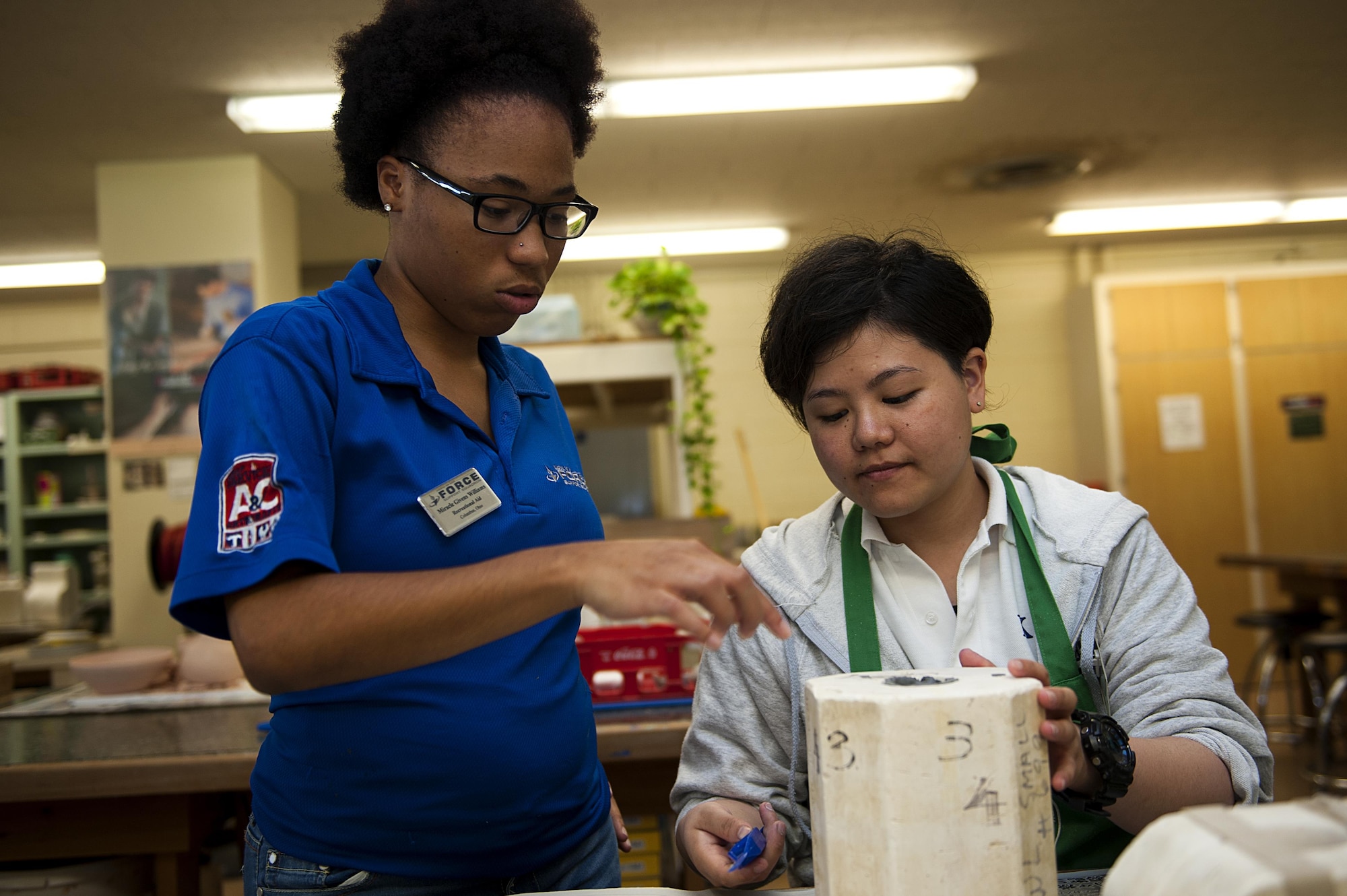 Haruka Fukuchi, 18th Force Support Squadron intern, learns how to make clay sculptures from Miracle Williams, 18th FSS recreational aid Aug. 24, 2016, at Kadena Air Base, Japan. On top of refining their English skills, KLI interns learn new skills and create new friendships with Airmen and American civilians alike. (U.S. Air Force photo by Airman 1st Class Corey M. Pettis)