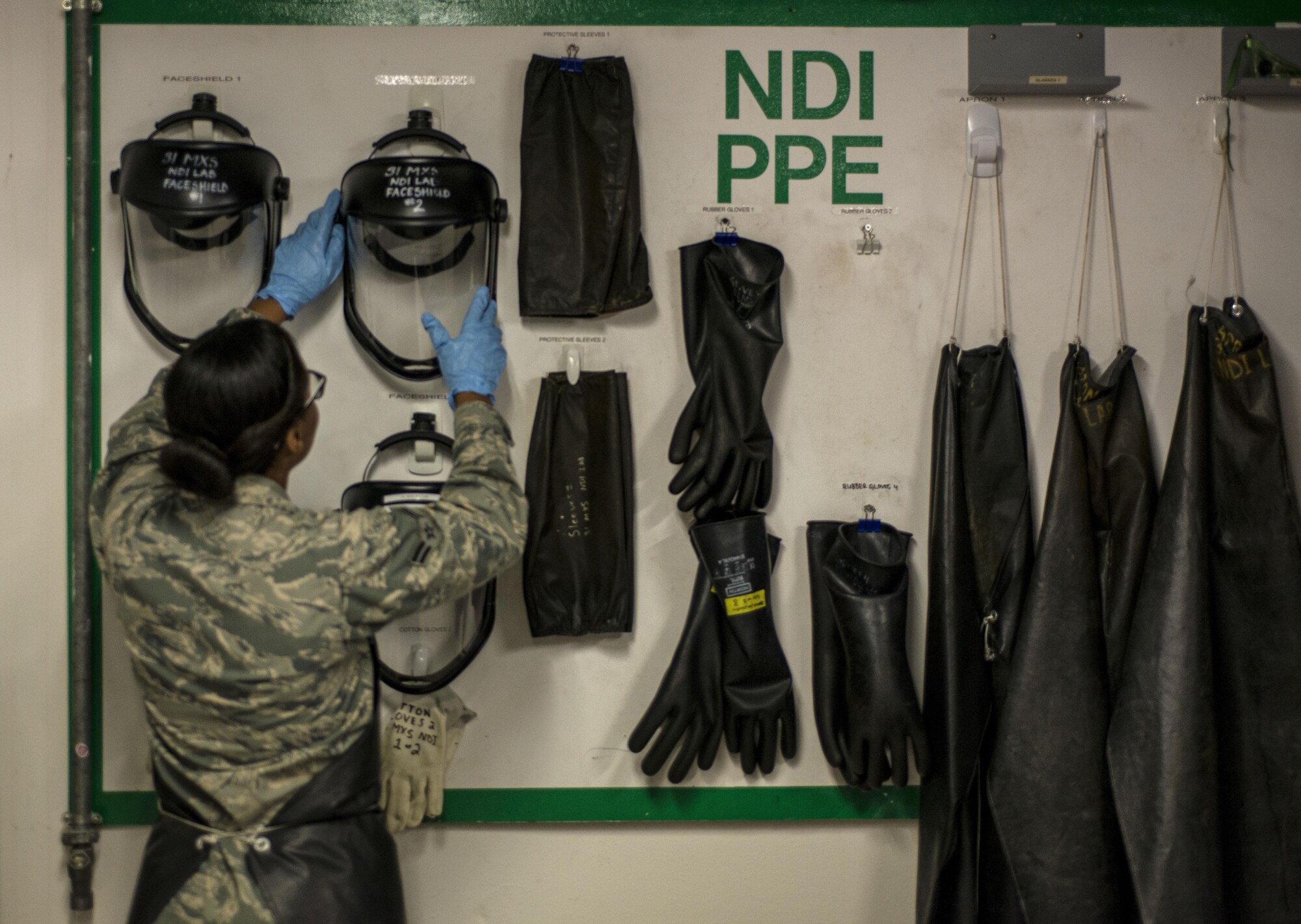 Airman 1st Class Victoria Proctor, 31st Maintenance Squadron non-destructive inspection apprentice, grabs a face shield, Aug. 23, 2016, at Aviano Air Base, Italy. Non-destructive inspection Airmen detect flaws such as cracks, voids, chips and heat damage with a wide variety of testing equipment. (U.S. Air Force photo by Airman 1st Class Cory W. Bush/Released)