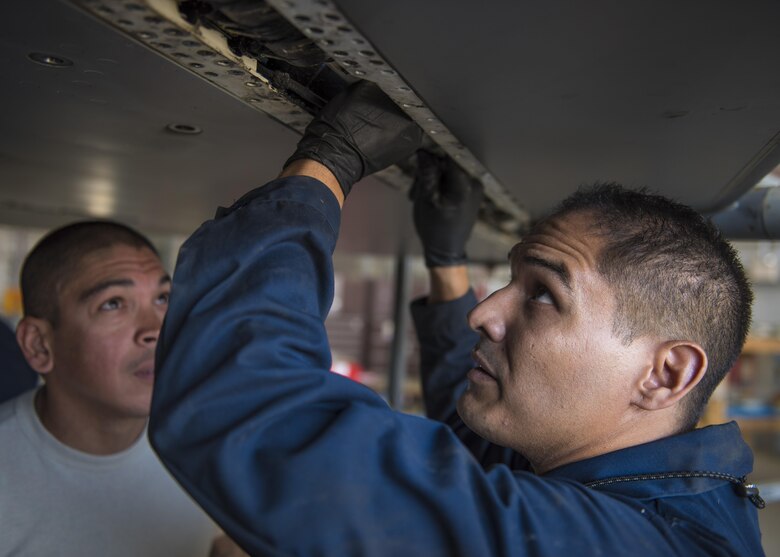 Technical Sgt. Freddie Candelaria, 455th Expeditionary Maintenance Squadron crew chief, installs torque shaft on an F-16C Fighting Falcon, Bagram Airfield, Afghanistan, Aug. 22, 2016. The torque shaft in the wing of the aircraft to help it achieve lift during takeoff. (U.S. Air Force photo by Senior Airman Justyn M. Freeman)