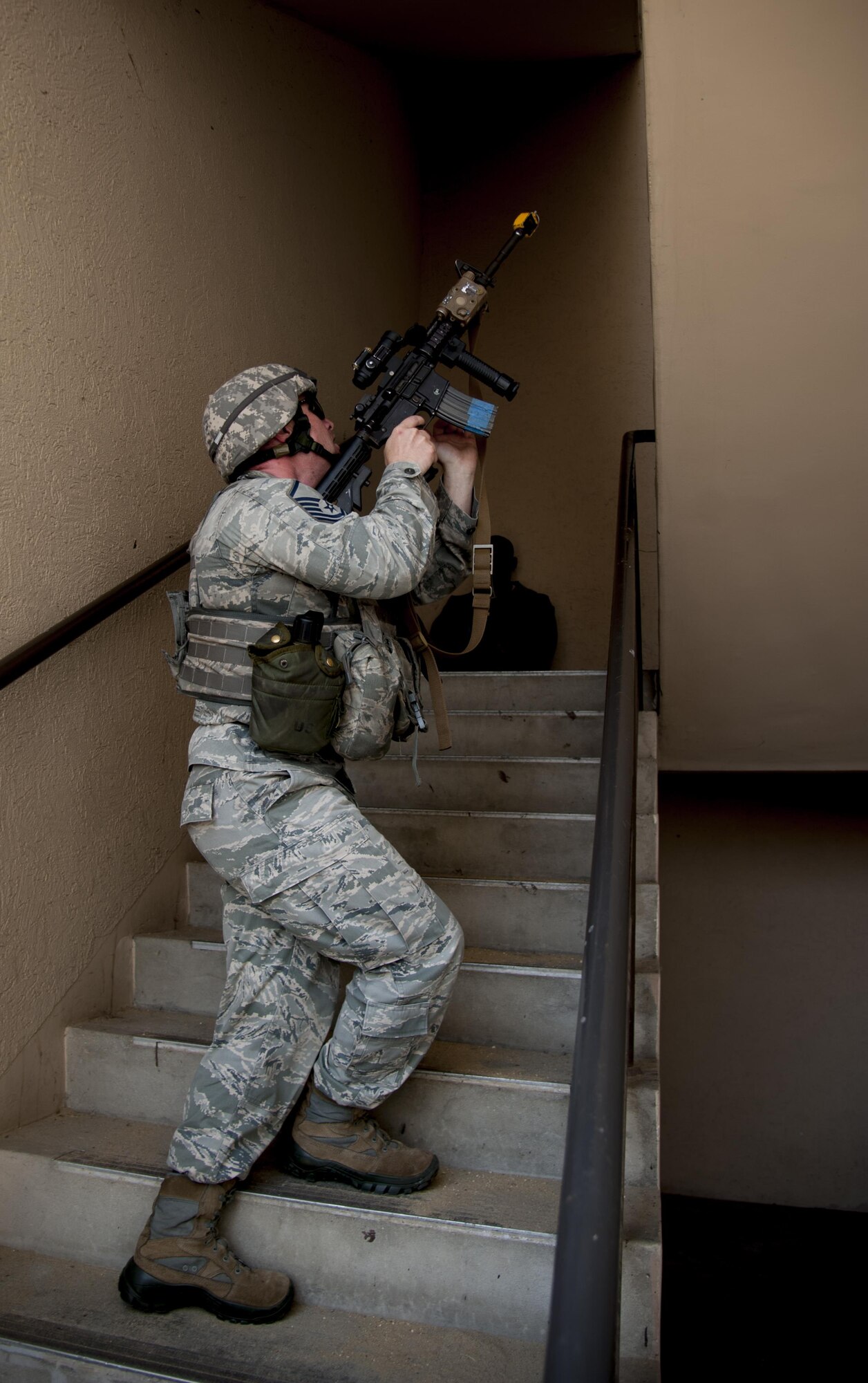 Master Sgt. Tim Shaw, 51st Security Forces flight chief, clears stairs during a mock attack on the 51st Communications Squadron building at Osan Air Base, Republic of Korea, Aug. 25, 2016. The mock attack allowed 51st CS Airmen to practice their base defense techniques procedures. (U.S. Air Force photo by Staff Sgt. Jonathan Steffen)