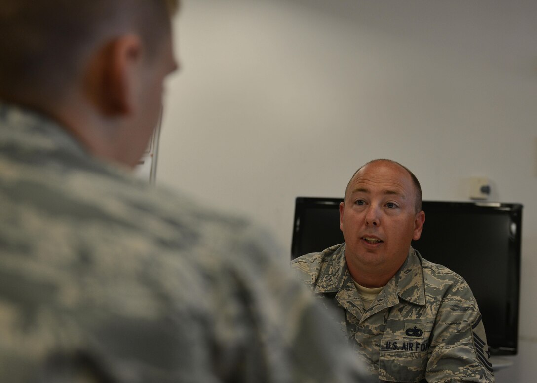 Master Sgt. Kevin Cantrell, 31st Munitions Squadron munitions systems equipment maintenance NCO in charge, speaks with his Airman during an office meeting, August 24, 2016 at Aviano Air Base, Italy. Cantrell uses his 17 years of ammunitions experience to provide mentorship to the workplace and guide his Airmen on professionalism, assertiveness and teaching them their job. (U.S. Air Force photo by Airman 1st Class Cary Smith/Released)