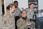 BUTLERVILLE, Ind. – Indiana National Guard Master Sgt. Bradley Staggs (sitting), of the 38th Infantry Division, shows U.S. Army Reserve Soldiers with the 206th Broadcast Operations Detachment and 205th Press Camp Headquarters how to run radio broadcast equipment during Exercise News Day at MUTC on Aug. 23, 2016.