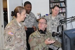 BUTLERVILLE, Ind. – Indiana National Guard Master Sgt. Bradley Staggs (sitting), of the 38th Infantry Division, shows U.S. Army Reserve Soldiers with the 206th Broadcast Operations Detachment and 205th Press Camp Headquarters how to run radio broadcast equipment during Exercise News Day at MUTC on Aug. 23, 2016.