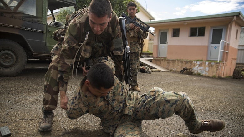 French Army Cpl. Alexis Ayglon, an infantryman, detains Lance Cpl. Jessie A. Rios, a rifleman, acting as a hostile enemy, during a French Armed Forces Nautical Commando Course at Quartier Gribeauval, New Caledonia, August 18, 2016. The course is a part of Exercise AmeriCal 16, a bilateral training exercise designed to enhance mutual combat capabilities and improve relations with our partners by exchanging a U.S. Marine Corps and French Armed Forces infantry platoon. While the U.S. Marines are in New Caledonia, the French infantry platoon traveled to Australia to participate in Exercise Koolendong 16 with U.S. and Australian forces. Ayglon, from Clermont Ferrand, France, is with 92nd Infantry Regiment, French Army. Rios, from Cottonwood, Arizona, is with Marine Rotational Force – Darwin. 