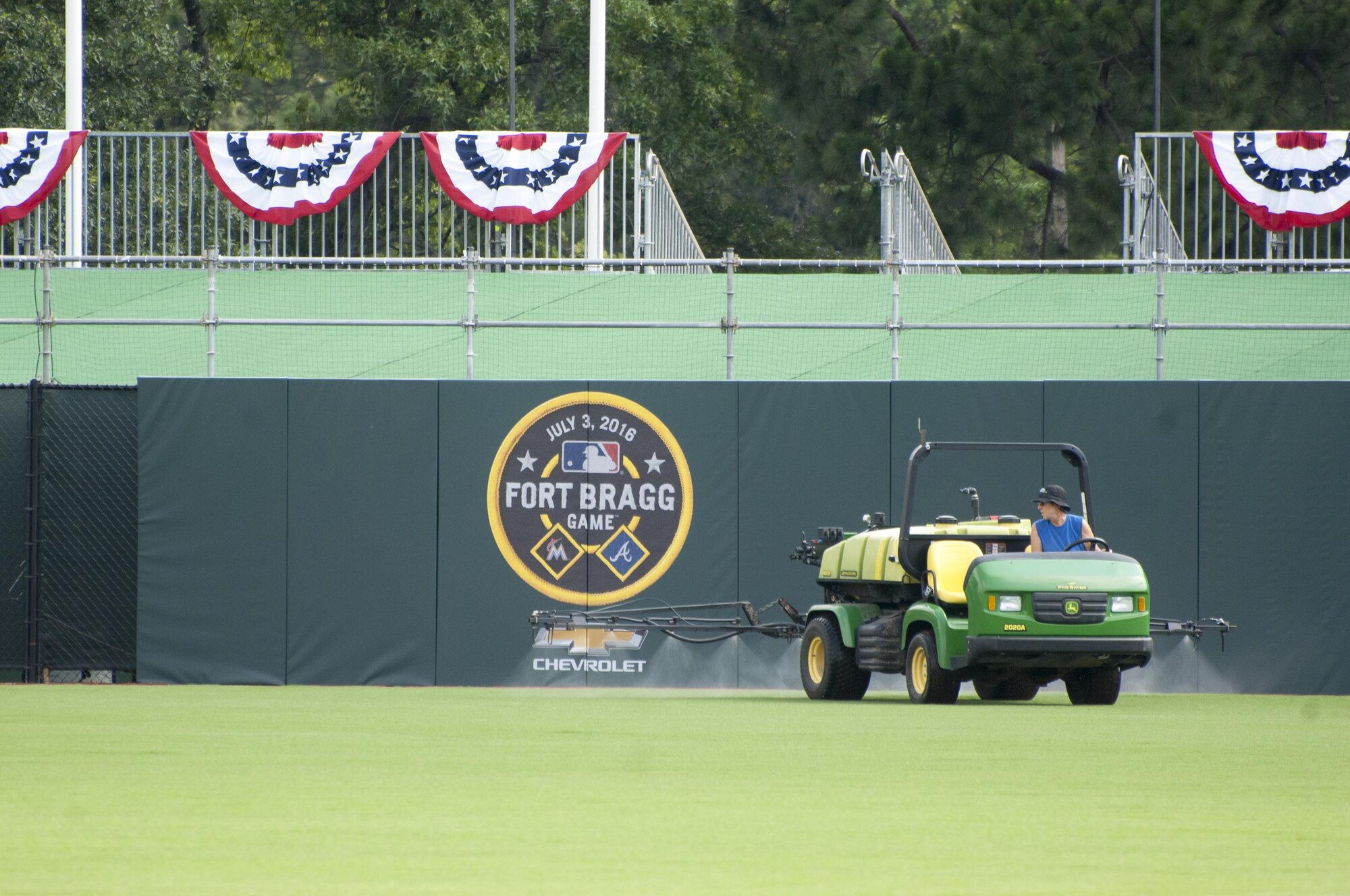A Major League Baseball contractor sprays the new field here at Fort Bragg during preparations for the Atlanta Braves vs. Miami Marlins baseball game, scheduled for July 3. 