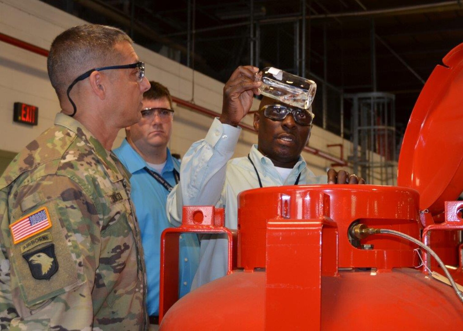 Anthony Whiteside, DLA Distribution Richmond ODS supervisor, explains how visual sample analysis of Halon are done to Army Brig. Gen. John Laskodi, DLA Distribution commander, during his visit to the distribution center on Aug. 12.  