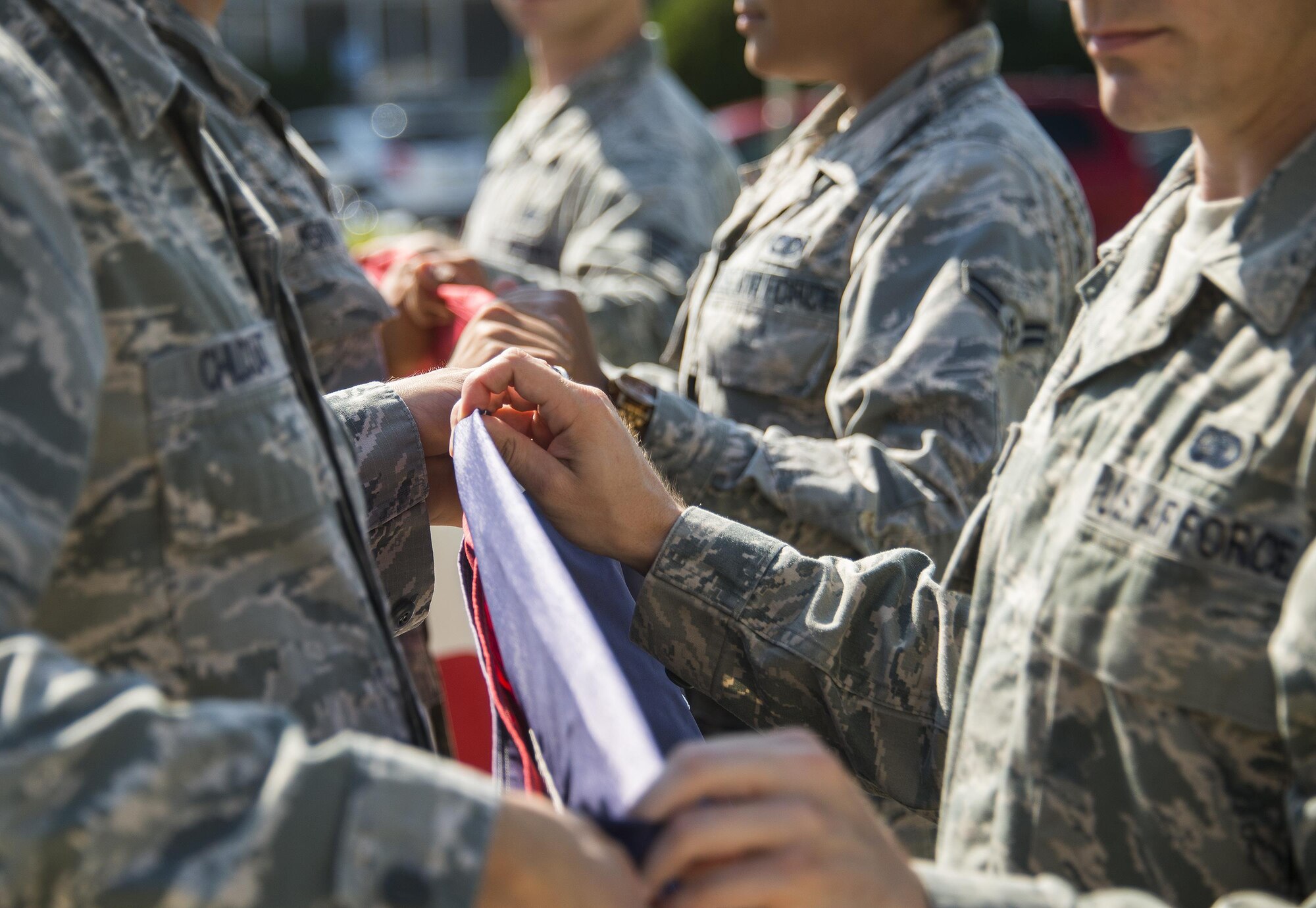 A group of 96th Logistics Readiness Squadron Airmen learn to fold the base flag Aug. 24 prior to their unit’s retreat ceremony the following day at Eglin Air Force Base, Fla.  Team Eglin hosts a reveille and retreat ceremony performed by a different base unit each month.  The 96th Test Wing’s command staff Airmen teach unit volunteers the proper procedures at practice sessions before the event usually held on the last Thursday of the month.  (U.S. Air Force photo/Samuel King Jr.)