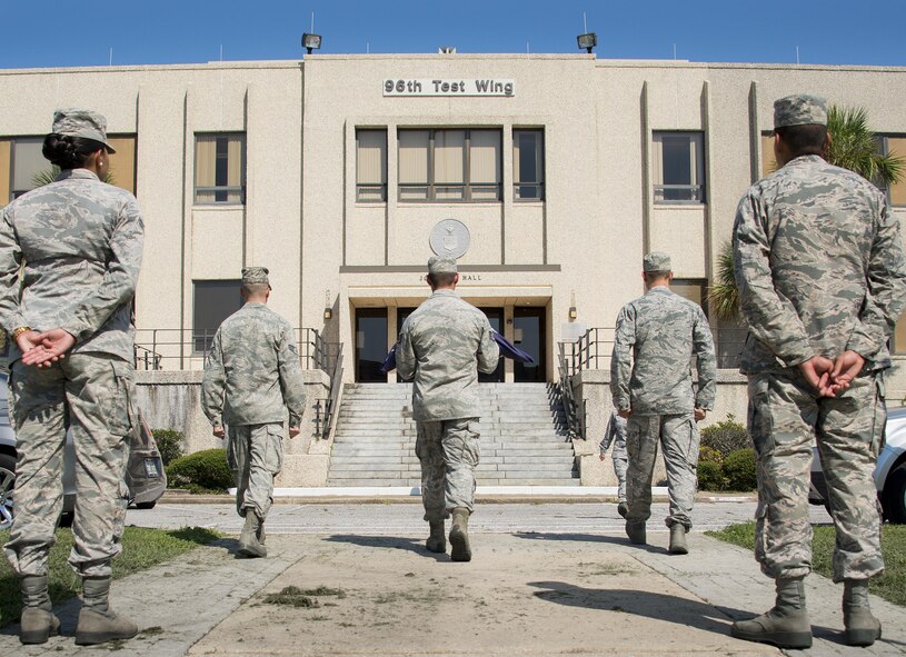 A group of 96th Logistics Readiness Squadron Airmen move toward the wing headquarters building to retire the flag during a practice session Aug. 24 prior to their unit’s retreat ceremony the following day at Eglin Air Force Base, Fla.  Team Eglin hosts a reveille and retreat ceremony performed by a different base unit each month.  The 96th Test Wing’s command staff Airmen teach unit volunteers the proper procedures at practice sessions before the event usually held on the last Thursday of the month.  (U.S. Air Force photo/Samuel King Jr.)