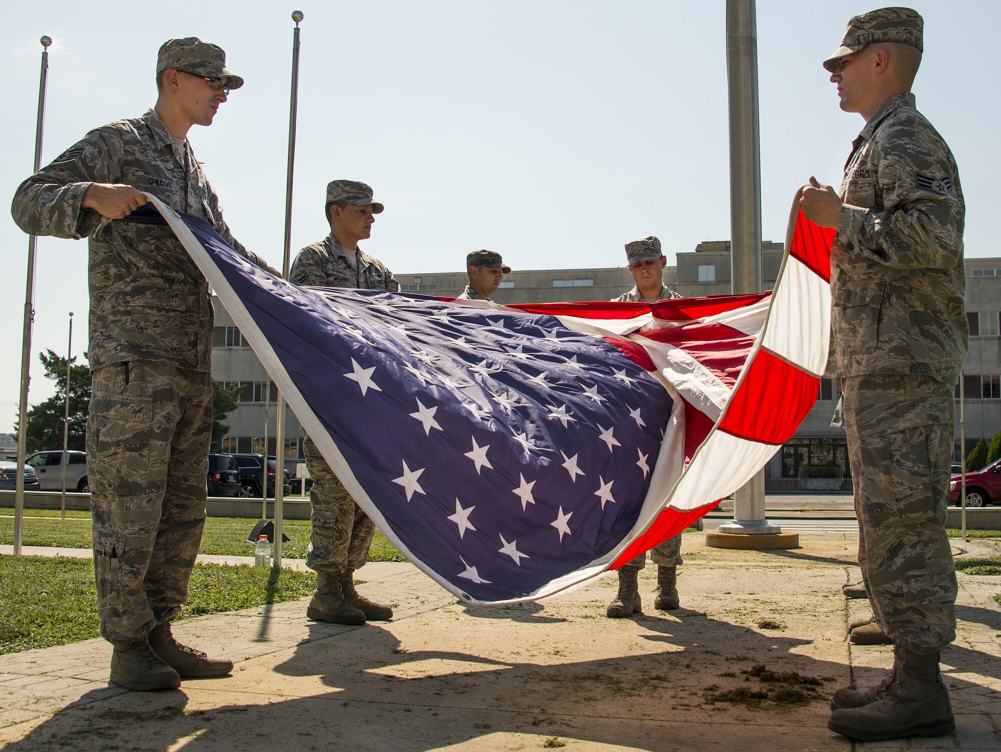 A group of 96th Logistics Readiness Squadron Airmen learn to fold the base flag Aug. 24 prior to their unit’s retreat ceremony the following day at Eglin Air Force Base, Fla.  Team Eglin hosts a reveille and retreat ceremony performed by a different base unit each month.  The 96th Test Wing’s command staff Airmen teach unit volunteers the proper procedures at practice sessions before the event usually held on the last Thursday of the month.  (U.S. Air Force photo/Samuel King Jr.)