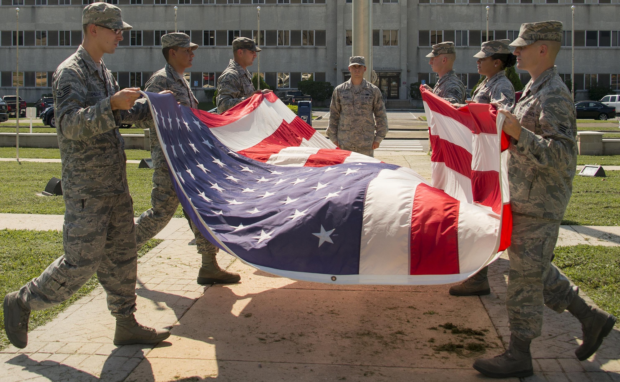A group of 96th Logistics Readiness Squadron Airmen learn to fold the base flag Aug. 24 prior to their unit’s retreat ceremony the following day at Eglin Air Force Base, Fla.  Team Eglin hosts a reveille and retreat ceremony performed by a different base unit each month.  The 96th Test Wing’s command staff Airmen teach unit volunteers the proper procedures at practice sessions before the event usually held on the last Thursday of the month.  (U.S. Air Force photo/Samuel King Jr.)