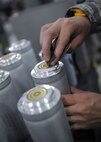 A 2nd Munitions Squadron Production Flight Airman cleans the contact points of a flare stick after the module failed a resistance test at Barksdale Air Force Base, La., August 18, 2016. When cleaning the stick, Airmen wear a grounding wrist strap to prevent setting off the flare. (U.S. Air Force photo/Airman 1st Class Stuart Bright)