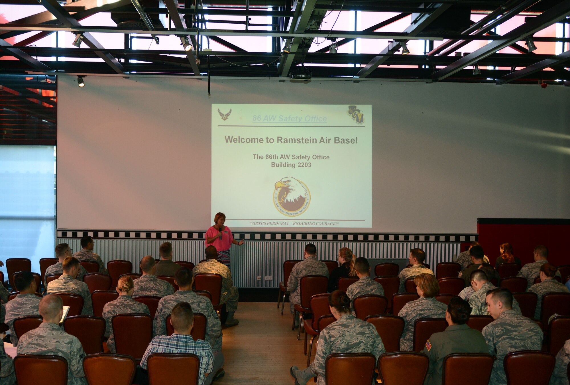 Kathy Keane, Airman and Family Readiness Center community readiness consultant, speaks to service members and their families during a base introduction brief Aug. 24, 2016 at Ramstein Air Base, Germany. Several base organizations brief newcomers on important community information such as housing, financial, legal, safety and local culture. (U.S. Air Force photo/ Airman 1st Class Joshua Magbanua)