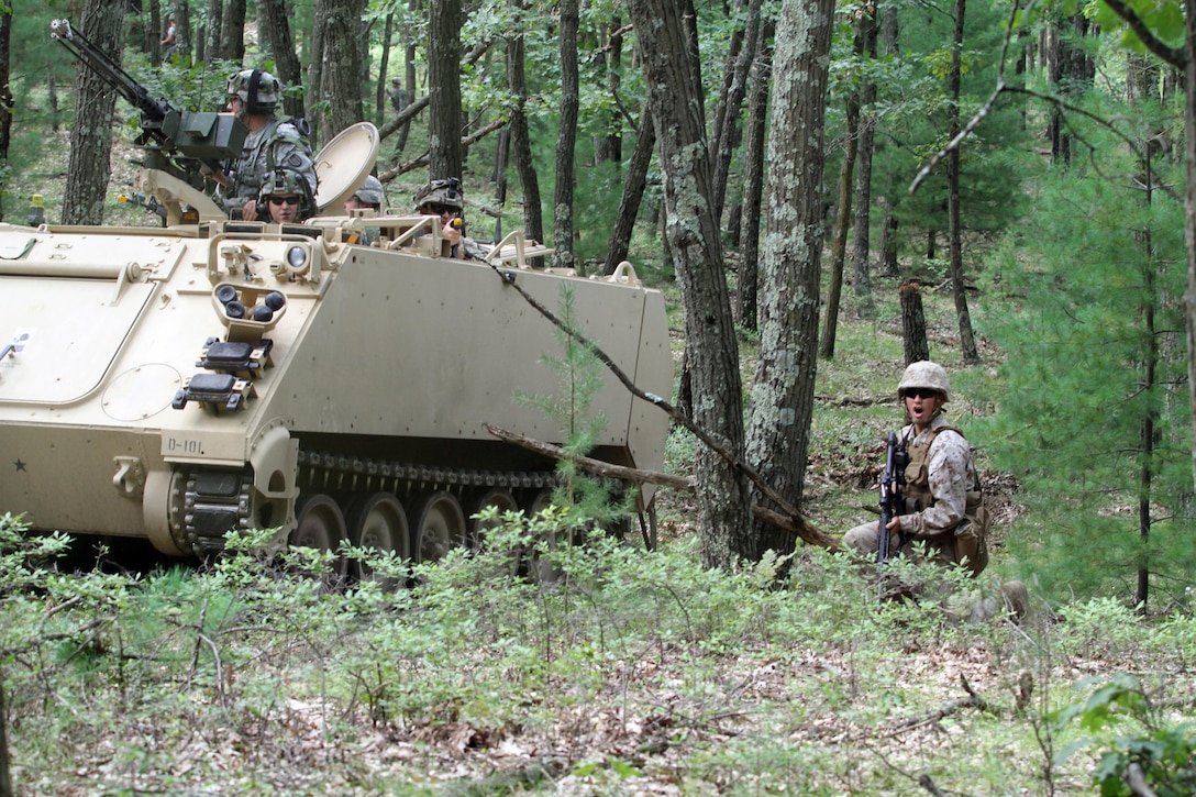 A U.S. Marine Reservist assigned to Headquarters and Service Company, 4th Medical Battalion,  takes cover beside a U.S. Army Reserve M113 Armored Personnel Carrier driven by 1st. Lt. Casey Reidy, Headquarters and Headquarters Company, 397th Engineer Battalion, 372nd Engineer Brigade, 416th Theater Support Command, as they react to a complex attack during Combat Support Training Exercise 86-16-03 (CSTX 86-16-03) on Fort McCoy, Wis., Aug. 22, 2016. Nearly 9,000 service members from across the country are participating in CSTX 86-16-03 hosted by the 86th Training Division and the 84th Training Command’s third and final CSTX of the year. (U.S. Army Reserve Photo by Sgt. 1st Class Clinton Wood).