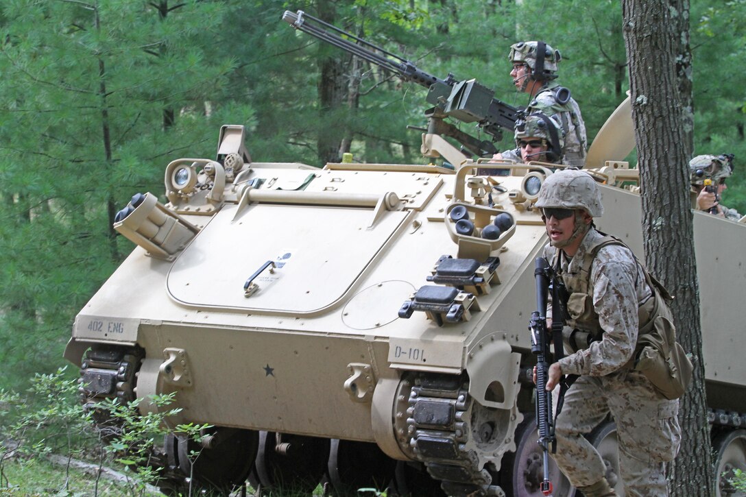 A U.S. Marine Reservist assigned to Headquarters and Service Company, 4th Medical Battalion,  takes cover beside a U.S. Army Reserve M113 Armored Personnel Carrier driven by 1st. Lt. Casey Reidy, Headquarters and Headquarters Company, 397th Engineer Battalion, 372nd Engineer Brigade, 416th Theater Support Command, as they react to a complex attack during Combat Support Training Exercise 86-16-03 (CSTX 86-16-03) on Fort McCoy, Wis., Aug. 22, 2016. Nearly 9,000 service members from across the country are participating in CSTX 86-16-03 hosted by the 86th Training Division and the 84th Training Command’s third and final CSTX of the year. (U.S. Army Reserve Photo by Sgt. 1st Class Clinton Wood).