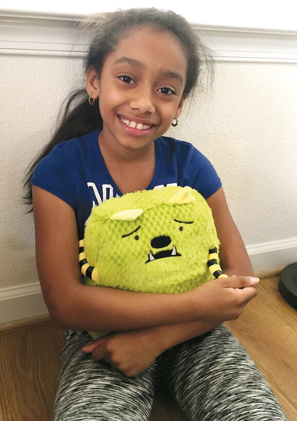 The Polanco's older daughter cuddles her plush Whatif Monster. Milly Polanco held a fundraiser this past April to purchase sets of the plush monster and its accompanying book, "Jonathan James and the Whatif Monster," for children working with the FOCUS team aboard Marine Corps Base Quantico. Photo courtesy Milly Polanco. 
