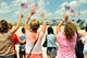 Friends and family of deployed unit members wave America flags as two C-130 Hercules aircraft taxi onto the 182nd Airlift Wing in Peoria, Ill., July 8, 2014. About 40 182nd aircrew and maintainers returned home from a deployment to Southwest Asia. They participated in Operation Enduring Freedom while assigned to the 379th Air Expeditionary Wing. (U.S. Air National Guard photo by Staff Sgt. Lealan Buehrer/Released)