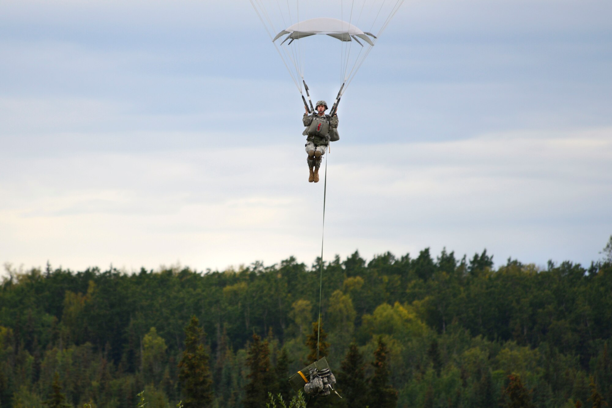 A paratrooper assigned to the 4th Infantry Brigade Combat Team (Airborne), 25th Infantry Division, U.S. Army Alaska, prepares to land during a joint forcible entry exercise at Malemute Drop Zone on Joint Base Elmendorf-Richardson, Alaska, Aug. 23, 2016, as part of Exercise Spartan Agoge. Spartan Agoge is a brigade-level field training exercise that began Aug. 15, and focuses on an array of combat-related tasks from squad live-fire exercises to helicopter air insertion and airborne assault training. (U.S. Air Force photo by Airman 1st Class Valerie Monroy)