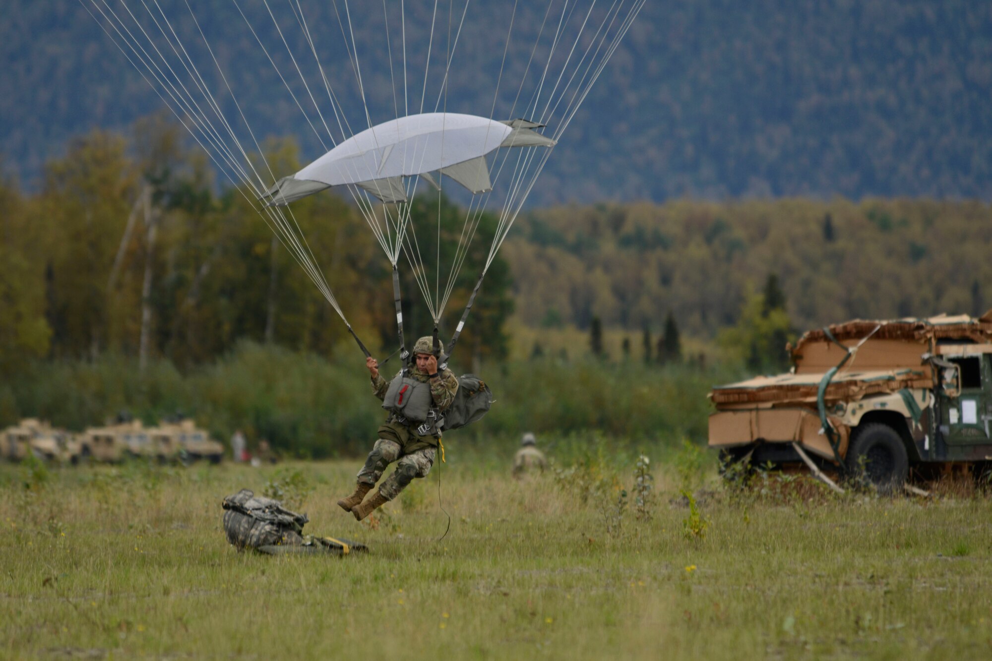 A paratrooper assigned to the 4th Infantry Brigade Combat Team (Airborne), 25th Infantry Division, U.S. Army Alaska, prepares to land during a joint forcible entry exercise at Malemute Drop Zone on Joint Base Elmendorf-Richardson, Alaska, Aug. 23, 2016, as part of Exercise Spartan Agoge. Spartan Agoge is a brigade-level field training exercise that began Aug. 15, and focuses on an array of combat-related tasks from squad live-fire exercises to helicopter air insertion and airborne assault training. (U.S. Air Force photo by Airman 1st Class Valerie Monroy)