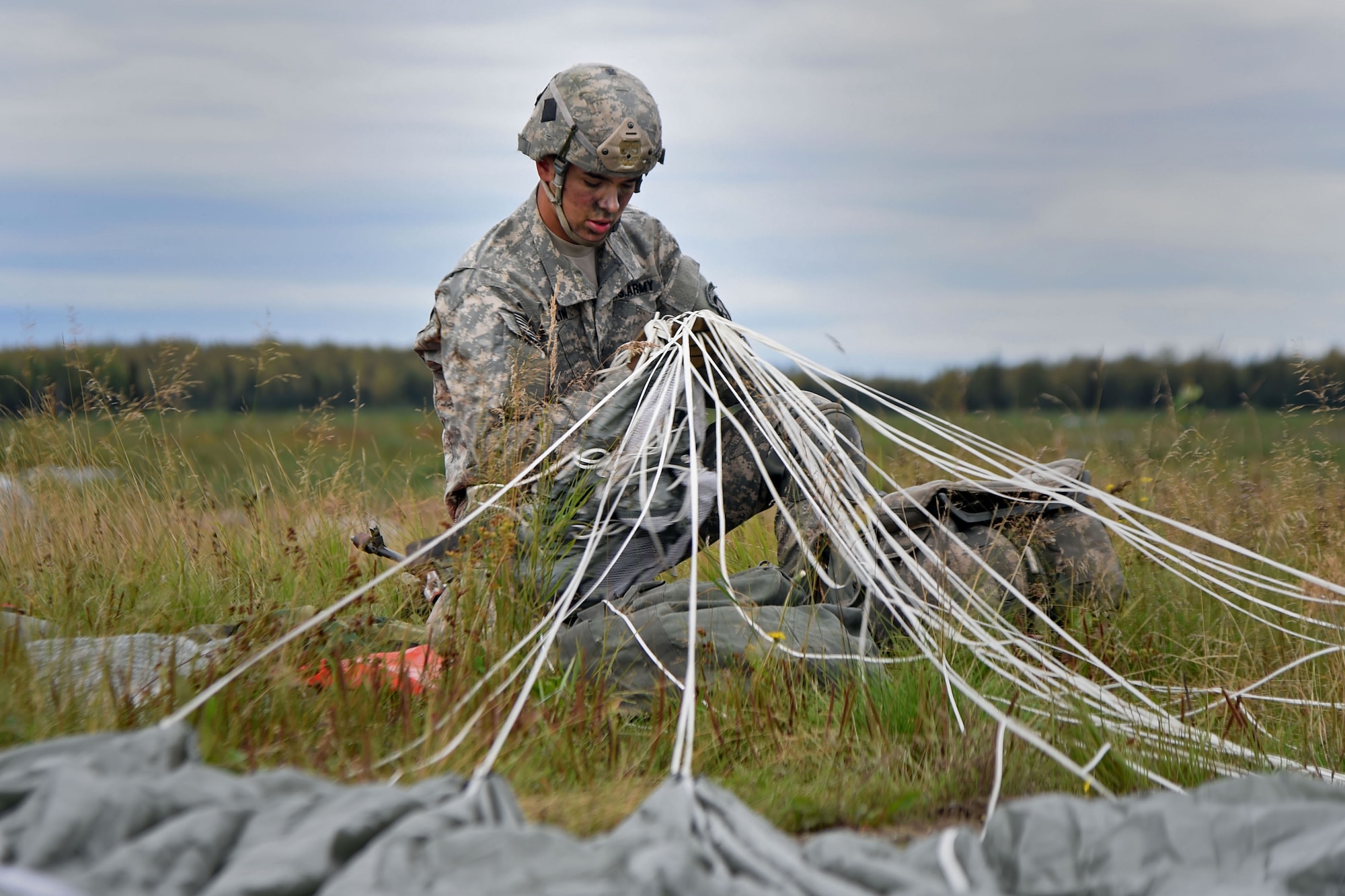 Pfc. Daniel Keplin, a native of Spokane, Washington, assigned to the1st Battalion, 501st Parachute Infantry Regiment, 4th Infantry Brigade Combat Team (Airborne), 25th Infantry Division, U.S. Army Alaska, gathers his gear during a joint forcible entry exercise at Malemute Drop Zone on Joint Base Elmendorf-Richardson, Alaska, Aug. 23, 2016, as part of Exercise Spartan Agoge. Spartan Agoge is a brigade-level field training exercise that began Aug. 15, and focuses on an array of combat-related tasks from squad live-fire exercises to helicopter air insertion and airborne assault training. (U.S. Air Force photo by Airman 1st Class Valerie Monroy)