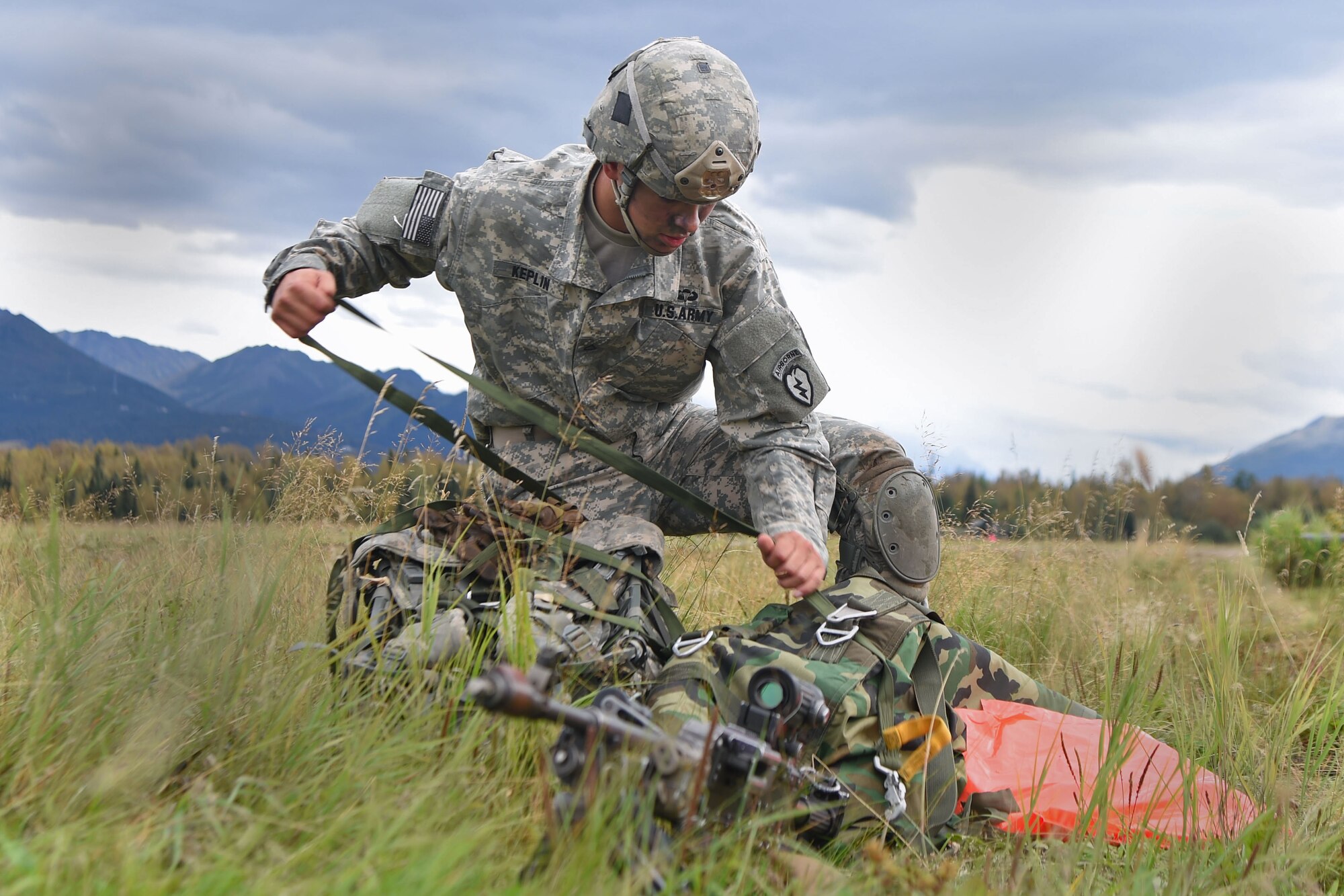 Pfc. Daniel Keplin, a native of Spokane, Washington, assigned to the1st Battalion, 501st Parachute Infantry Regiment, 4th Infantry Brigade Combat Team (Airborne), 25th Infantry Division, U.S. Army Alaska, gathers his gear during a joint forcible entry exercise at Malemute Drop Zone on Joint Base Elmendorf-Richardson, Alaska, Aug. 23, 2016, as part of Exercise Spartan Agoge. Spartan Agoge is a brigade-level field training exercise that began Aug. 15, and focuses on an array of combat-related tasks from squad live-fire exercises to helicopter air insertion and airborne assault training. (U.S. Air Force photo by Airman 1st Class Valerie Monroy)