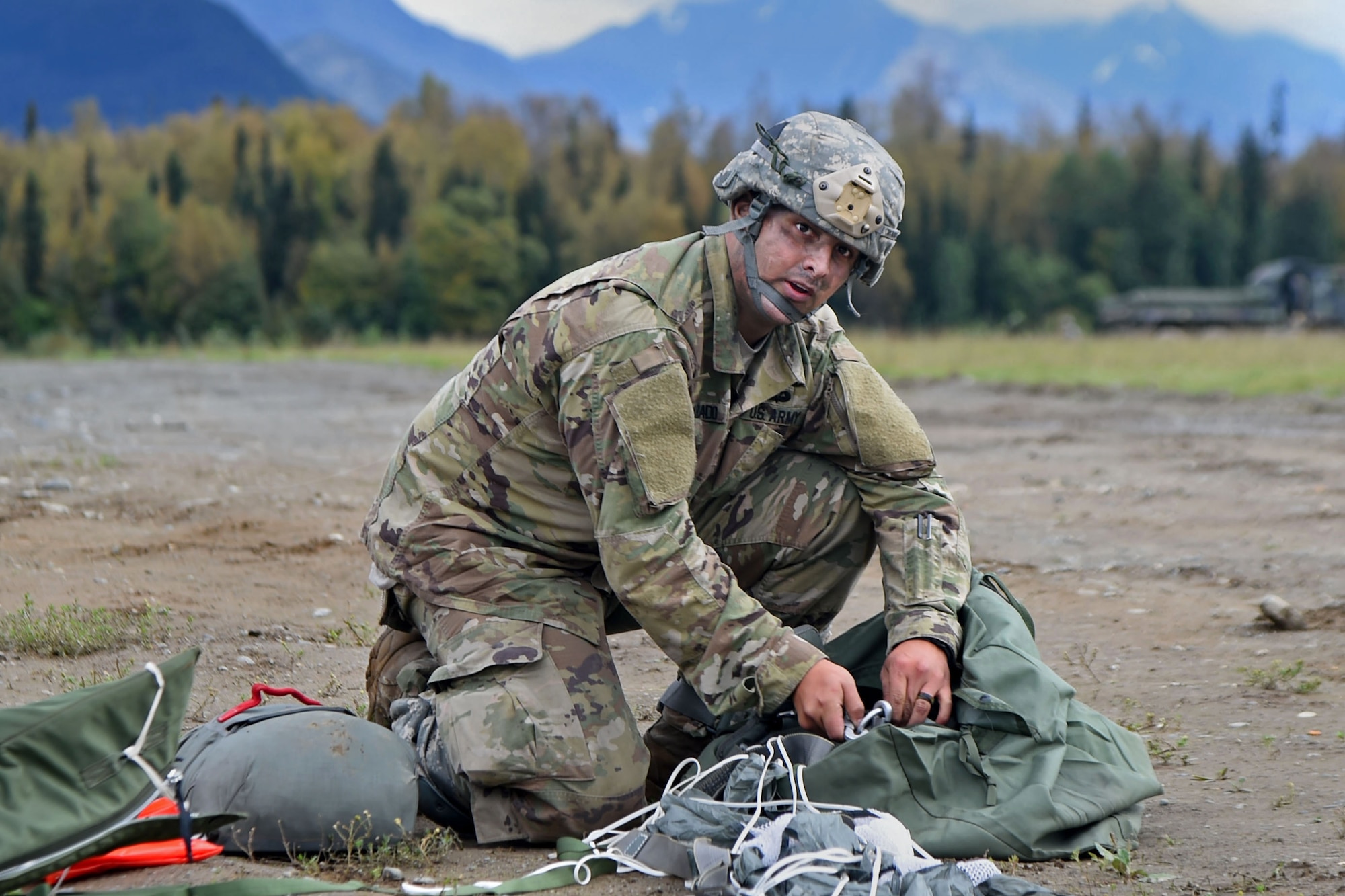 Spc. Henry Alvarado, a native of Los Angeles, assigned to the 1st Battalion, 501st Parachute Infantry Regiment, 4th Infantry Brigade Combat Team (Airborne), 25th Infantry Division, U.S. Army Alaska, gathers his gear during a joint forcible entry exercise at Malemute Drop Zone on Joint Base Elmendorf-Richardson, Alaska, Aug. 23, 2016, as part of Exercise Spartan Agoge. Spartan Agoge is a brigade-level field training exercise that began Aug. 15, and focuses on an array of combat-related tasks from squad live-fire exercises to helicopter air insertion and airborne assault training. (U.S. Air Force photo by Airman 1st Class Valerie Monroy)