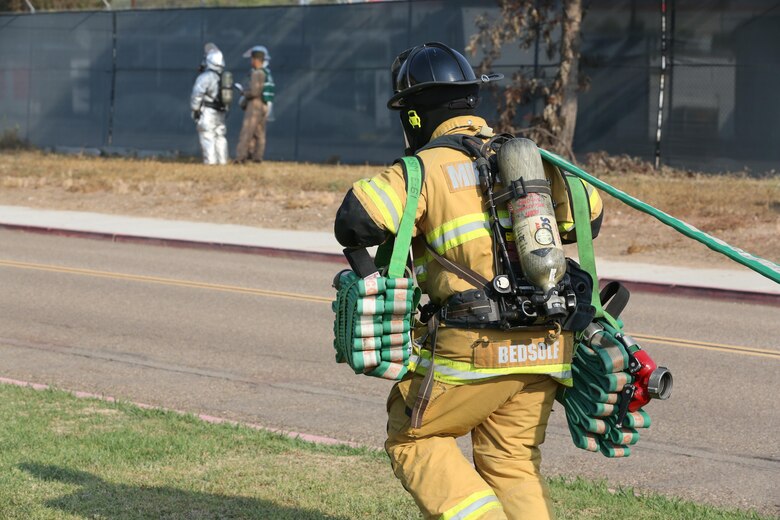 A firefighter with the Marine Corps Air Station Miramar Fire Department runs toward a simulated aircraft crash during an aircraft mass casualty exercise aboard MCAS Miramar, Calif., Aug. 24. Marines with Aircraft Rescue and Firefighting and firefighters with the MCAS Miramar Fire Department worked alongside San Diego first responders to improve response times, solidify existing standard operating procedures for emergencies and fulfill annual training requirements. (U.S. Marine Corps photo by Pfc. Jake M.T. McClung/Released)