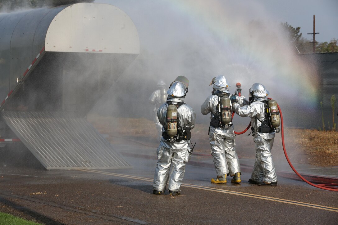 Marines with Aircraft Rescue and Firefighting douse a simulated aircraft with water during an aircraft mass casualty exercise aboard Marine Corps Air Station Miramar, Calif., Aug. 24. Marines with ARFF and firefighters with the MCAS Miramar Fire Department worked alongside San Diego first responders to improve response times, solidify existing standard operating procedures for emergencies and fulfill annual training requirements. (U.S. Marine Corps photo by Pfc. Jake M.T. McClung/Released)