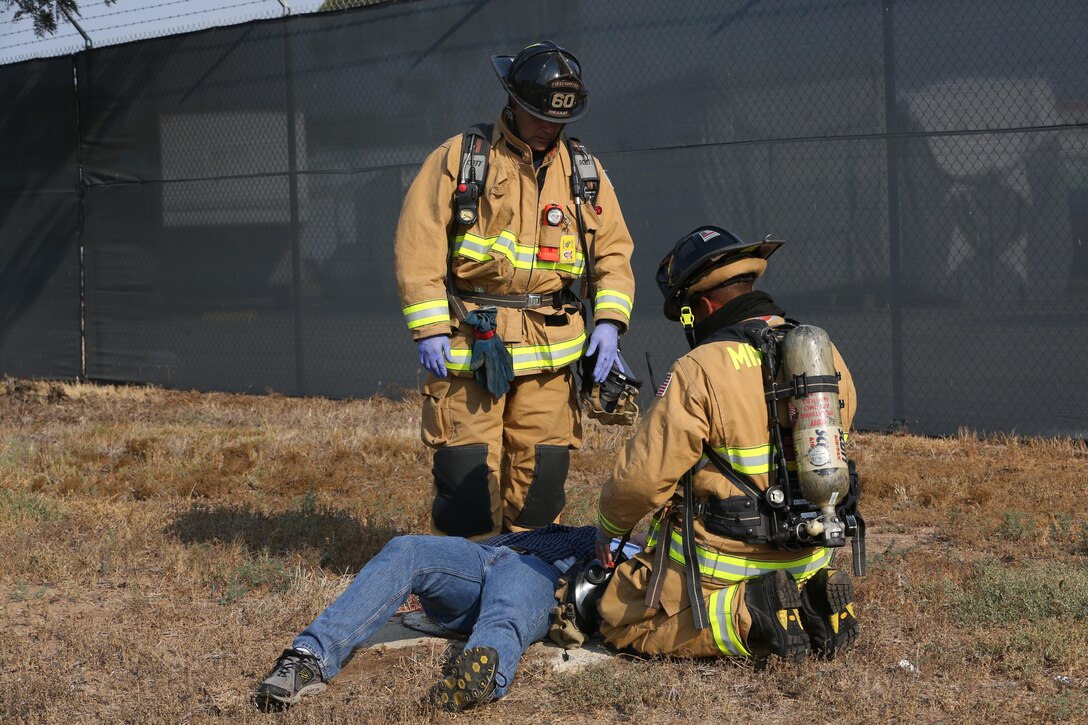 Firefighters with the Marine Corps Air Station Miramar Fire Department provide assistance to a simulated casualty during an aircraft mass casualty exercise aboard MCAS Miramar, Calif., Aug. 24. Marines with Aircraft Rescue and Firefighting and firefighters with the MCAS Miramar Fire Department worked alongside San Diego first responders to improve response times, solidify existing standard operating procedures for emergencies and fulfill annual training requirements. 