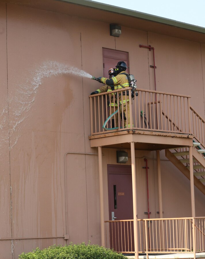 Firefighters with the Marine Corps Air Station Miramar Fire Department work to extinguish a simulated building fire during an aircraft mass casualty exercise aboard MCAS Miramar, Calif., Aug. 24. Marines with Aircraft Rescue and Firefighting and firefighters with the MCAS Miramar Fire Department worked alongside San Diego first responders to improve response times, solidify existing standard operating procedures for emergencies and fulfill annual training requirements. (U.S. Marine Corps photo by Pfc. Jake M.T. McClung/Released)