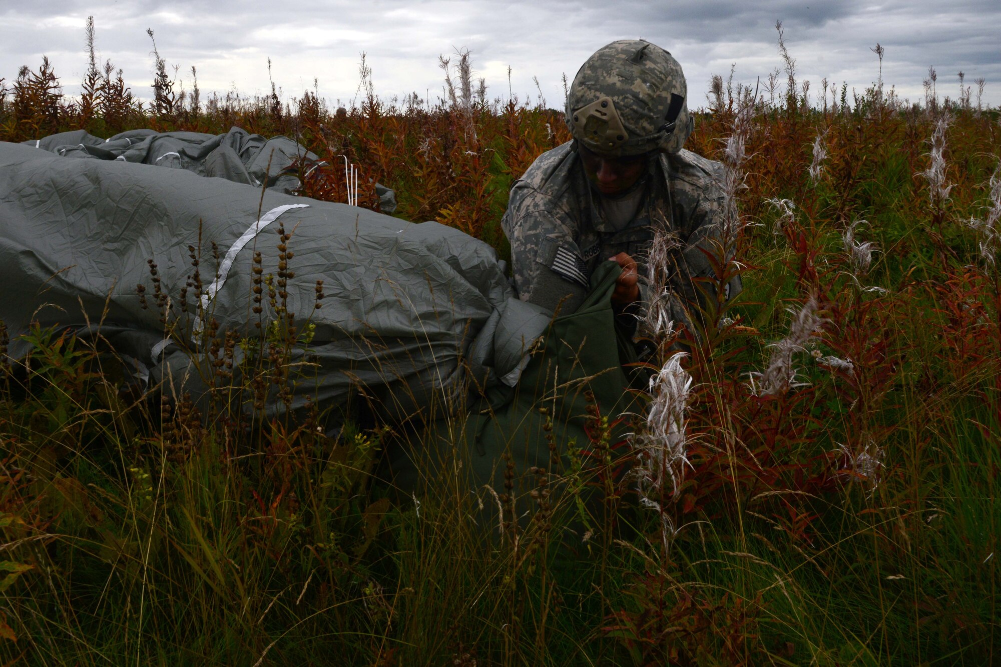 Pfc.Timothy Robbins, a paratrooper assigned to 1st Battalion, 501st Parachute Infantry Regiment, 4th Infantry Brigade Combat Team (Airborne), 25th Infantry Division, U.S. Army Alaska, recovers his parachute during a joint forcible entry exercise at Malemute Drop Zone on Joint Base Elmendorf-Richardson, Alaska, Aug. 23, 2016, as part of Exercise Spartan Agoge. Spartan Agoge is a brigade-level field training exercise that began Aug. 15, focused on an array of combat-related tasks from squad live-fire exercises to helicopter air insertion and airborne training. (U.S. Air Force Airman 1st Class Javier Alvarez)