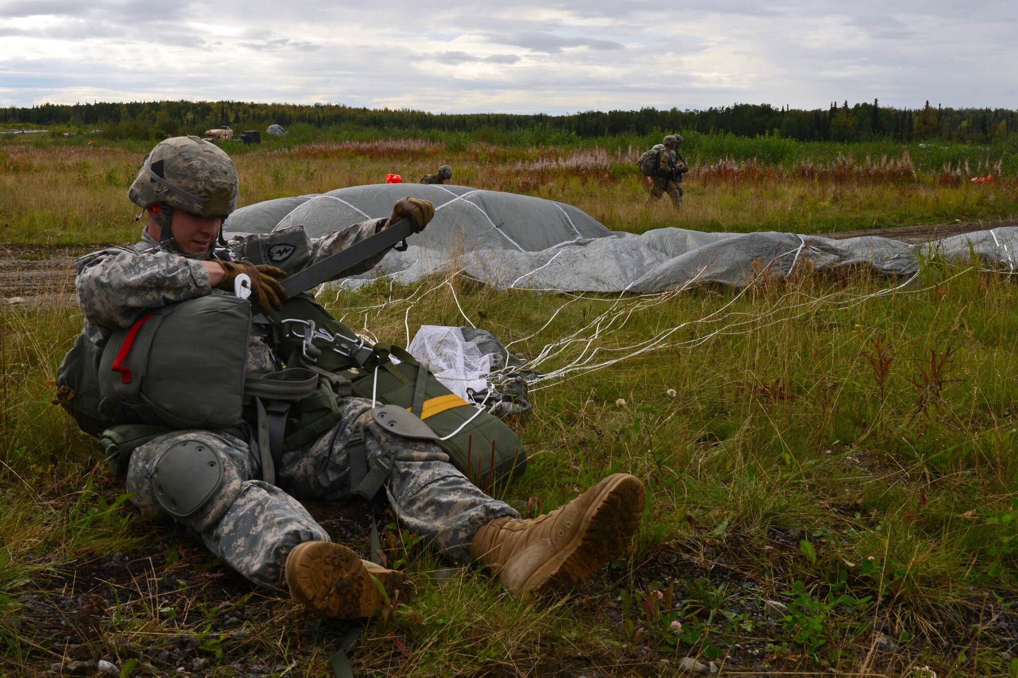 Spc. Sterling Rutherford, a paratrooper assigned to 1st Battalion, 501st Parachute Infantry Regiment, 4th Infantry Brigade Combat Team (Airborne), 25th Infantry Division, U.S. Army Alaska, removes his parachute during a joint forcible entry exercise at Malemute Drop Zone on Joint Base Elmendorf-Richardson, Alaska, Aug. 23, 2016, as part of Exercise Spartan Agoge. Spartan Agoge is a brigade-level field training exercise that began Aug. 15, focused on an array of combat-related tasks from squad live-fire exercises to helicopter air insertion and airborne training. (U.S. Air Force Airman 1st Class Javier Alvarez)