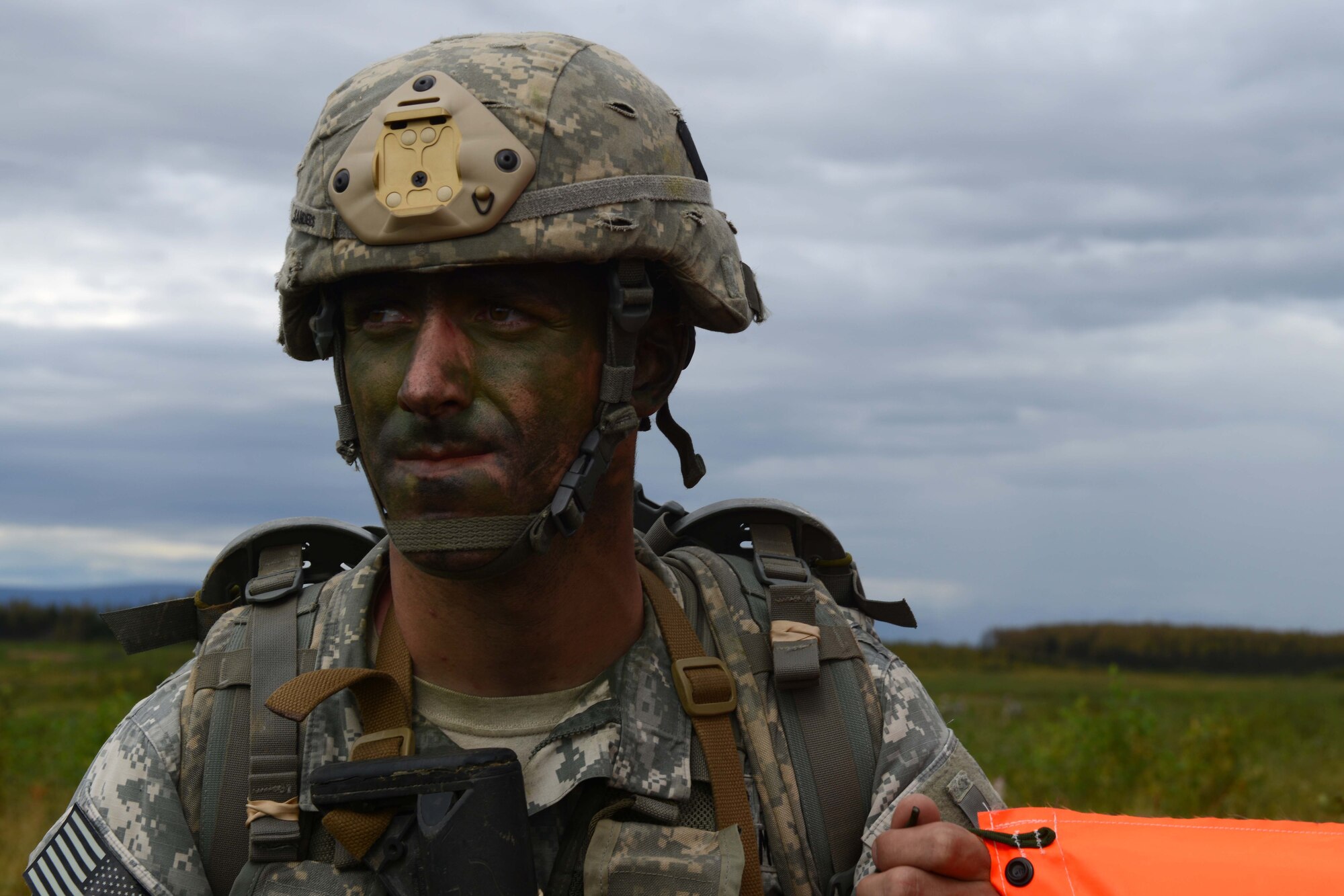 A paratrooper assigned to 1st Battalion, 501st Parachute Infantry Regiment, 4th Infantry Brigade Combat Team (Airborne), 25th Infantry Division, U.S. Army Alaska, holds a VS-17 panel marking his assembly area during a joint forcible entry exercise at Malemute Drop Zone on Joint Base Elmendorf-Richardson, Alaska, Aug. 23, 2016, as part of Exercise Spartan Agoge. Spartan Agoge is a brigade-level field training exercise that began Aug. 15, focused on an array of combat-related tasks from squad live-fire exercises to helicopter air insertion and airborne training. (U.S. Air Force Airman 1st Class Javier Alvarez)