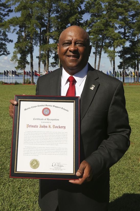 Retired Lt. Col. John Cassidy Dockery, displays a certificate of recognition on behalf of Pvt. John Henry Dockery, received during the Montford Point Day Ceremony at Camp Johnson on Marine Corps Base Camp Lejeune, Aug. 25. During the ceremony, three family members were presented a certificate of recognition and a Congressional Gold Medal on behalf of their relatives who were members of the original Montford Point Marines. (U.S. Marine Corps photo by Cpl. Mark Watola /Released)