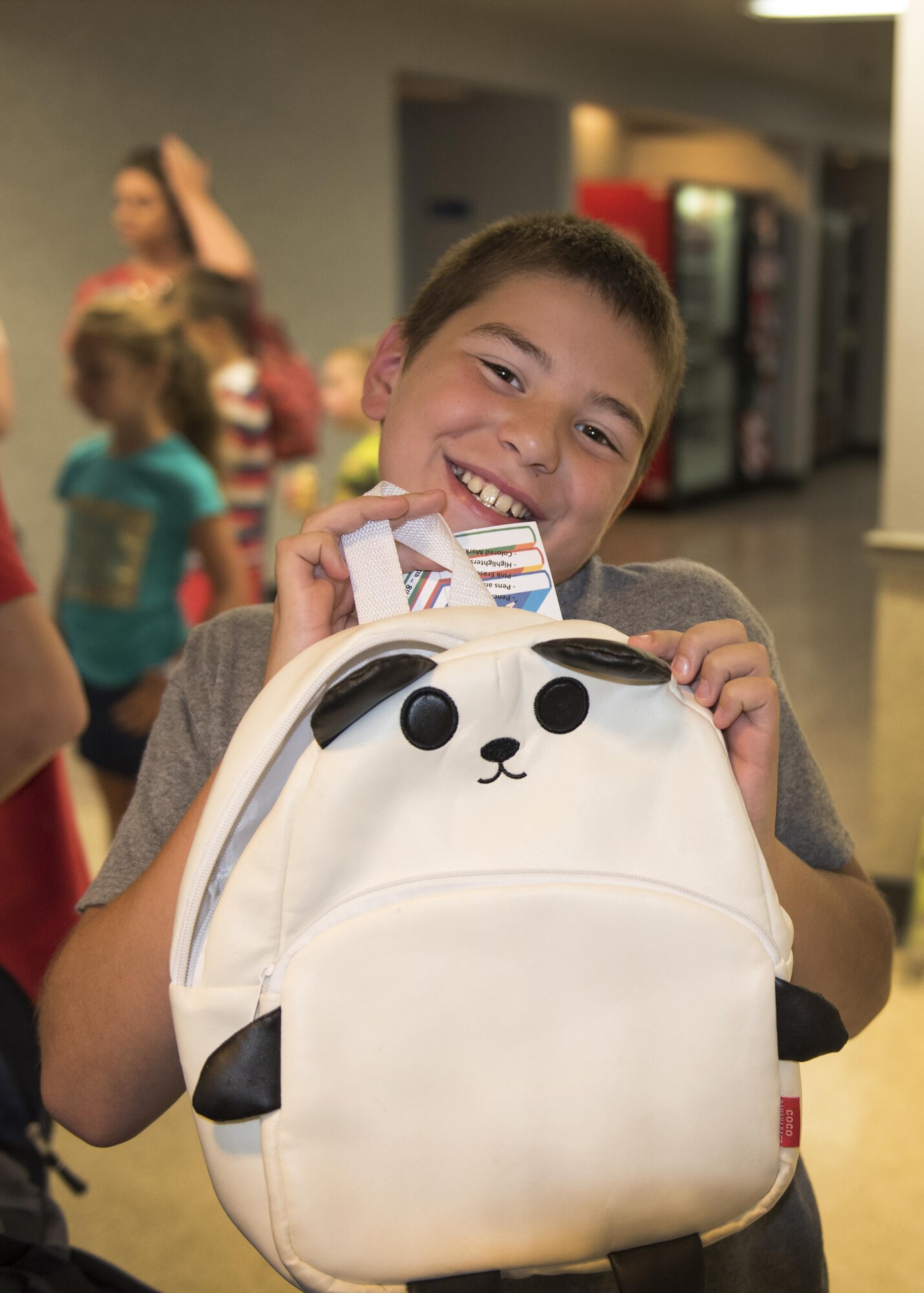 A boy poses with a backpack at the Passenger Terminal on Joint Base McGuire-Dix-Lakehurst, N.J., Aug. 24, 2016. School supplies and about 300 backpacks were donated by the Liberty United Service Organizations at the Project Einstein event here.