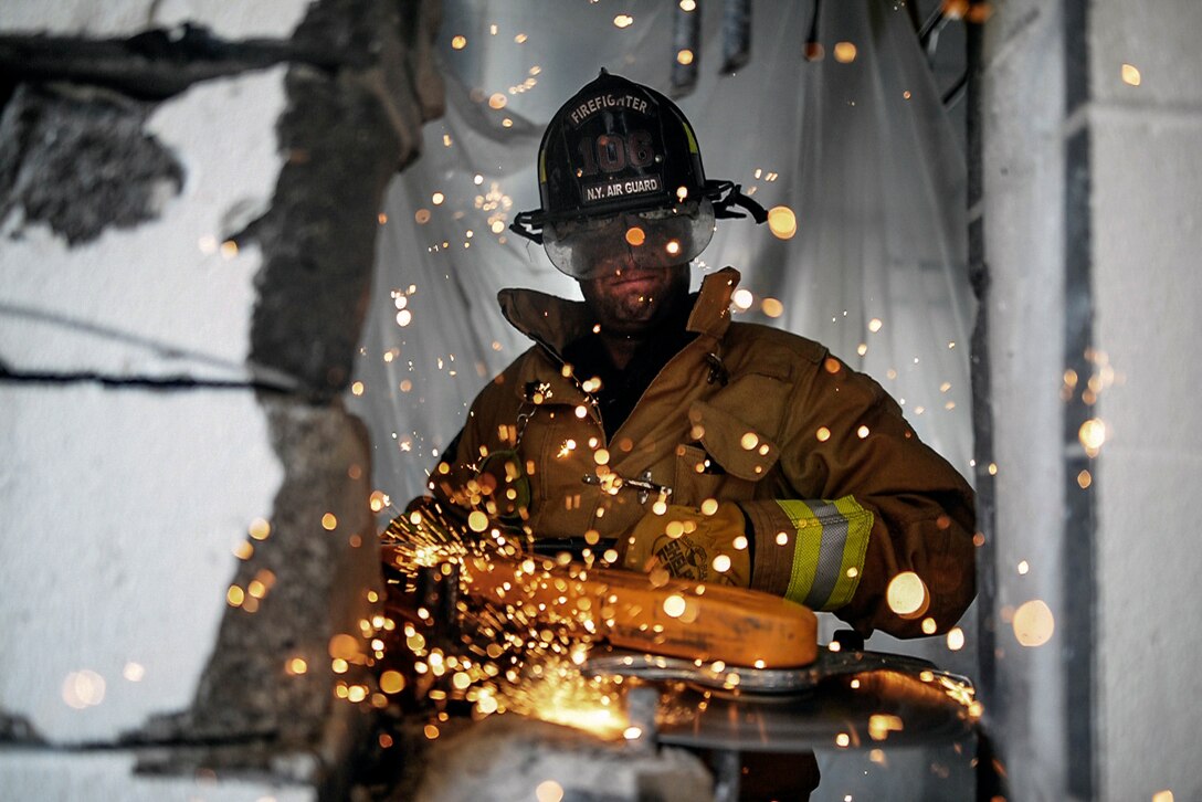 Air Force Staff Sgt. Daniel Glenn cuts through a reinforced cinder block wall with a power saw at Francis S. Gabreski Air National Guard Base in Westhampton Beach, N.Y., Aug. 25, 2016. Pravato is a firefighter assigned to the New York Air National Guard's 106th Rescue Wing. Air National Guard photo by Staff Sgt. Christopher S. Muncy