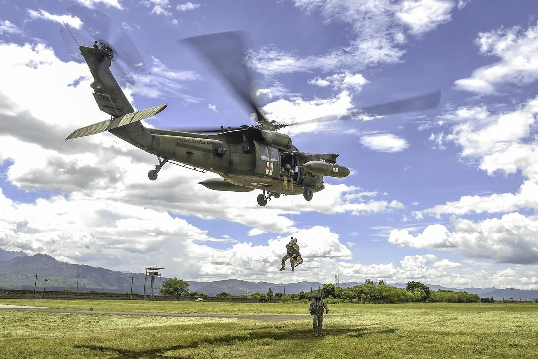 A UH-60L Black Hawk helicopter hoists Army Spc. Courtney Moreland, a military working dog handler, and her dog, Puma, during K-9 evacuation training at Soto Cano Air Base, Honduras, Aug. 15, 2016. Moreland is assigned to Joint Task Force Bravo’s Joint Security Forces. Air Force photo by Staff Sgt. Siuta B. Ika