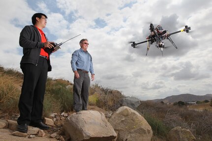Michael Yeh, left, and Gary Lunt, NSWC Corona engineers, demonstrate their patent-pending Cycloptic Scoring System (CYCLOPSS) project. Through the Naval Innovative Science and Engineering (NISE) program, Yeh and Lunt are developing a low-cost, lightweight weapons impact scoring system (WISS), utilizing unmanned aerial vehicles (UAVs), for use in remote locations or at sea. 