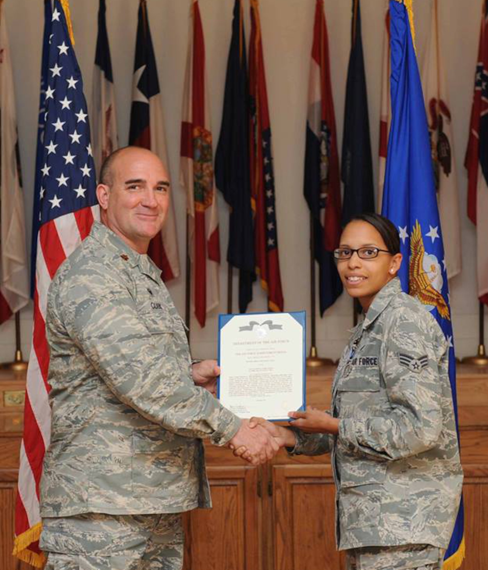 U.S. Air Force Maj. Brant Clark, 7th Comptroller Squadron commander, awards Senior Airman Shannon Hall, 7th Bomb Wing Public Affairs photojournalist the Air Force Achievement Medal April 23, 2014, at Dyess Air Force Base, Texas.  Hall received the medal after completing numerous hours of funerals, retirements and other ceremonies while a member of the Dyess Honor Guard. (U.S. Air Force photo by Airman 1st Class Alexander Guerrero/Released)