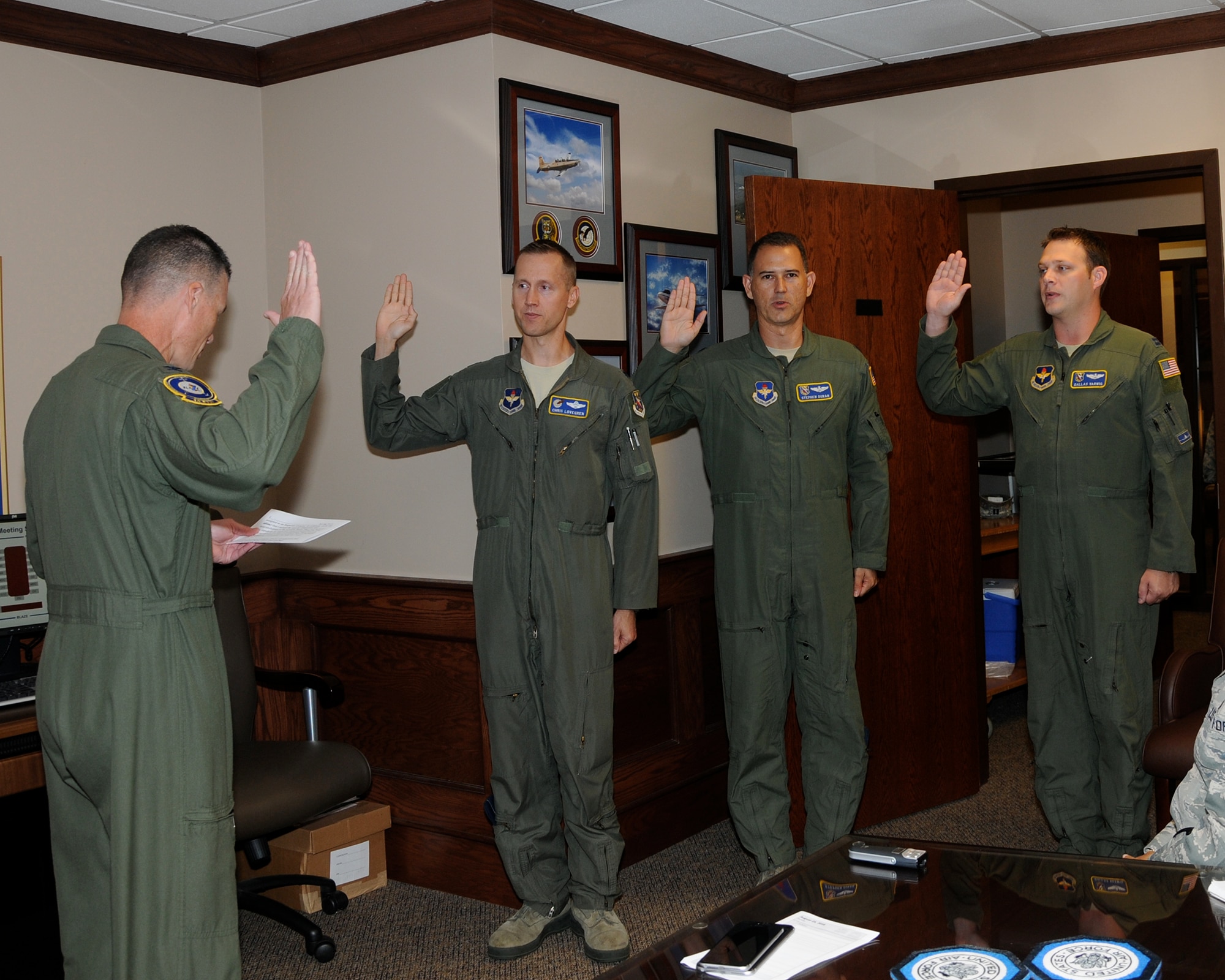 Col. Douglas Gosney, 14th Flying Training Wing Commander, administers the Oath of the Inspector General and presents the Inspector General Badge to Lt. Col. Chris Lovegren, Lt. Col. Stephen Duran and Capt. Dallas Varwig Aug. 25 on Columbus Air Force Base, Mississippi.  These officers will lead the 14th FTW's execution of the Air Force Inspection System and the Unit Effective Inspection Capstone event scheduled for Jan. 23-30, 2017. (U.S. Air Force photo/Melissa Doublin)