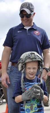Bradley and his dad, Maj. Dan Lambrecht, try on a tactical helmet and gloves during the annual Herc Adventure Tour at Peterson Air Force Base, Colo., Aug. 6, 2016. The Herc Adventure Tour provides Air Force Reservists and their families the opportunity to tour the 302nd Airlift Wing's assigned aircraft as well as experience the equipment operated by several other organizations within the wing. Lambrecht is assigned to the 731st Airlift Squadron. (U.S. Air Force photo/2nd Lt. Stephen J. Collier)
