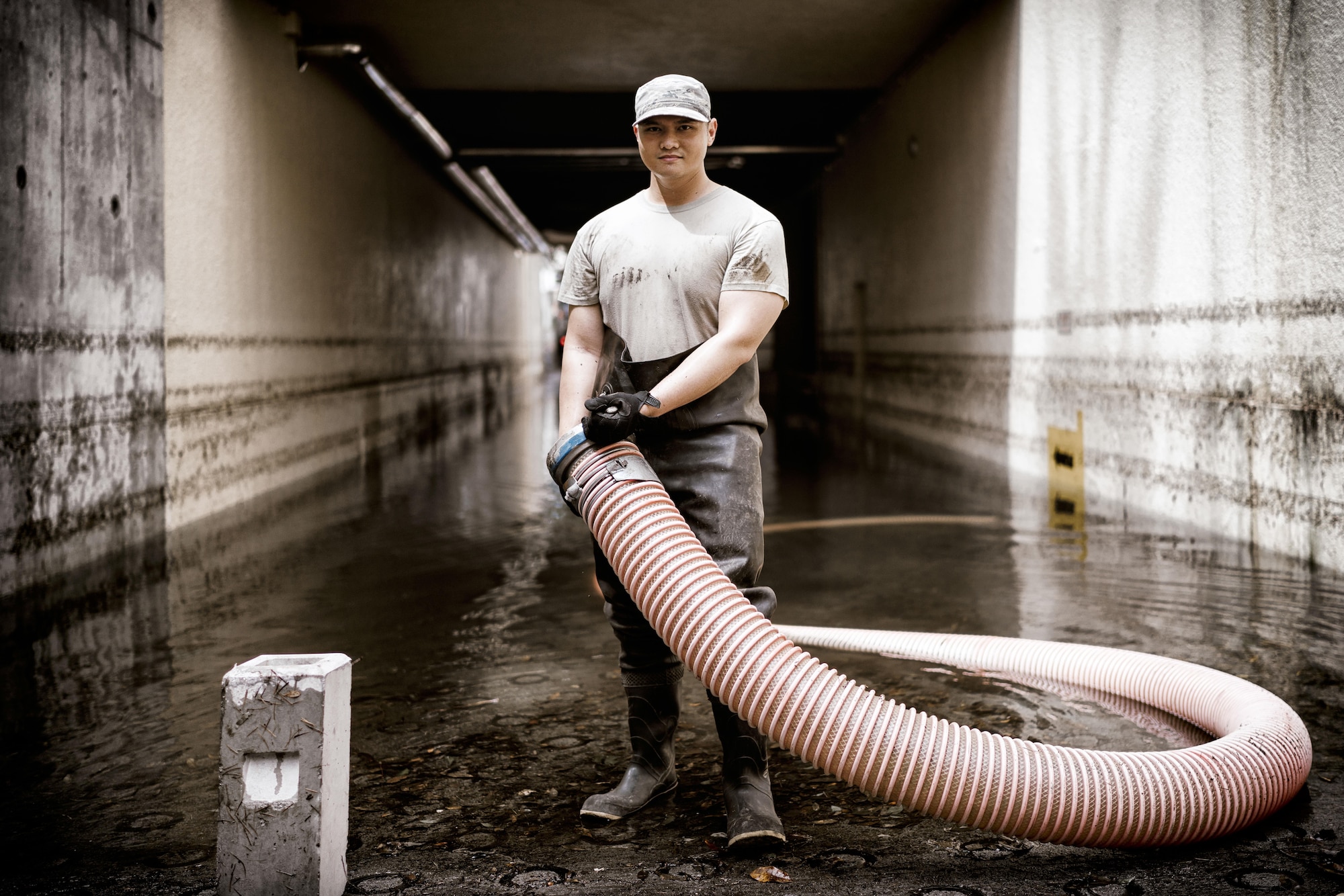 Senior Airman Christian Leyson, 374th Civil Engineer Squadron water and fuels systems maintenance journeyman, prepares to connect a hose to a generator at Yokota Air Base, Japan, Aug. 23, 2016. Tropical Storm Mindulle struck Yokota Aug. 22, causing flooding, power outages and physical damage. More than 300 families were relocated to housing with bedding, power and hot water in the wake of the storm. The 374 CES, other emergency response units on base and community volunteers assisted, and continue to assist, with the recovery. (U.S. Air Force photo by Senior Airman Delano Scott/Released)