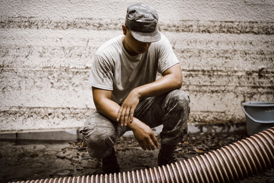 Senior Airman Julius Bennett, 374th Civil Engineer Squadron water and fuels systems maintenance journeyman, examines a water pump hose at Yokota Air Base, Japan, Aug. 23, 2016. Tropical Storm Mindulle struck Yokota Aug. 22, causing flooding, power outages and physical damage. More than 300 families were relocated to housing with bedding, power and hot water in the wake of the storm. The 374 CES, other emergency response units on base and community volunteers assisted, and continue to assist, with the recovery. (U.S. Air Force photo by Senior Airman Delano Scott/Released)