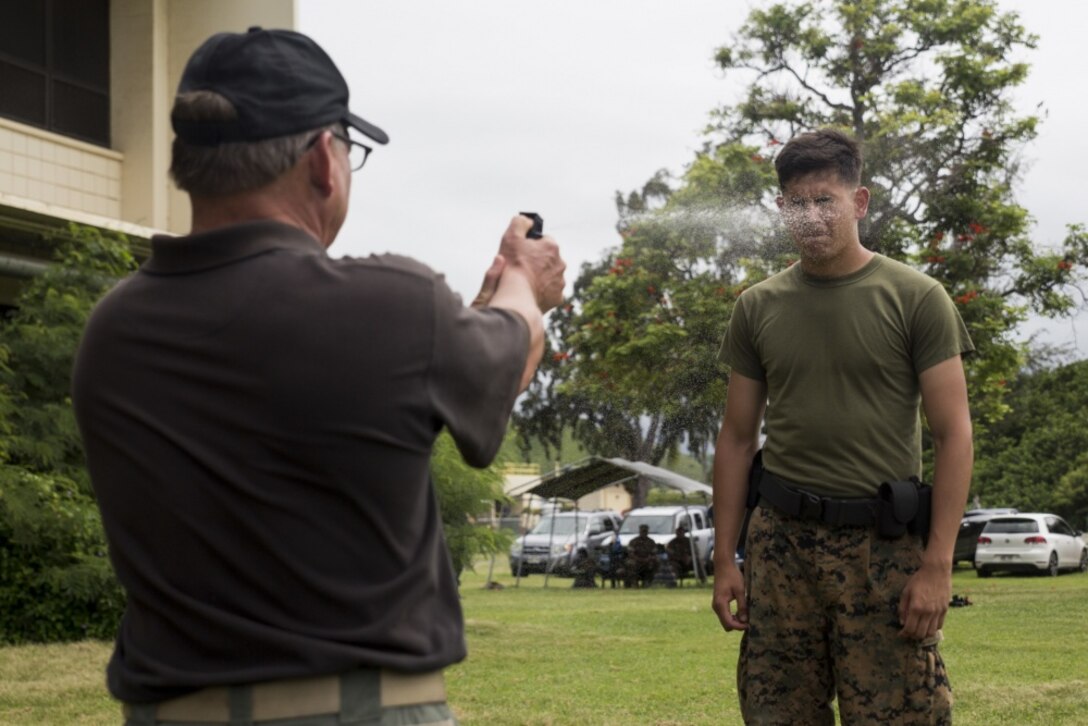 MARINE CORPS BASE HAWAII – Lance Cpl. Robert Bates, a rifleman with 1st Battalion, 3rd Marine Regiment, and a Broken Bow, Ok., native, is pepper sprayed during a defensive and offensive tactics course near the Provost Marshal’s Office aboard Marine Corps Base Hawaii, Aug. 18, 2016. Marines from various units are undergoing a two-week training course to support the PMO as part of the Gate Augmentation Force. One of the training requirements necessary for completing the program, service members must conduct defensive and offensive tactics in response to a simulated attack after having been pepper sprayed. Instructors exposed the service members to the spray in order to reinforce the importance of remaining calm, should they be contaminated by it in the future. (U.S. Marine Corps photo by Lance Cpl. Jesus Sepulveda Torres) 