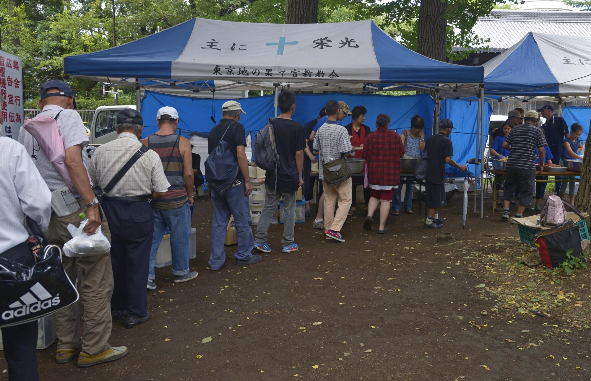 Homeless people wait in line to receive food at Ueno Park, Tokyo, Japan, Aug. 19, 2016. The Yokota Air Base Chapel has worked with local churches for approximately 10 years to provide help for homeless people. (U.S. Air Force photo by Senior Airman David Owsianka/Released)